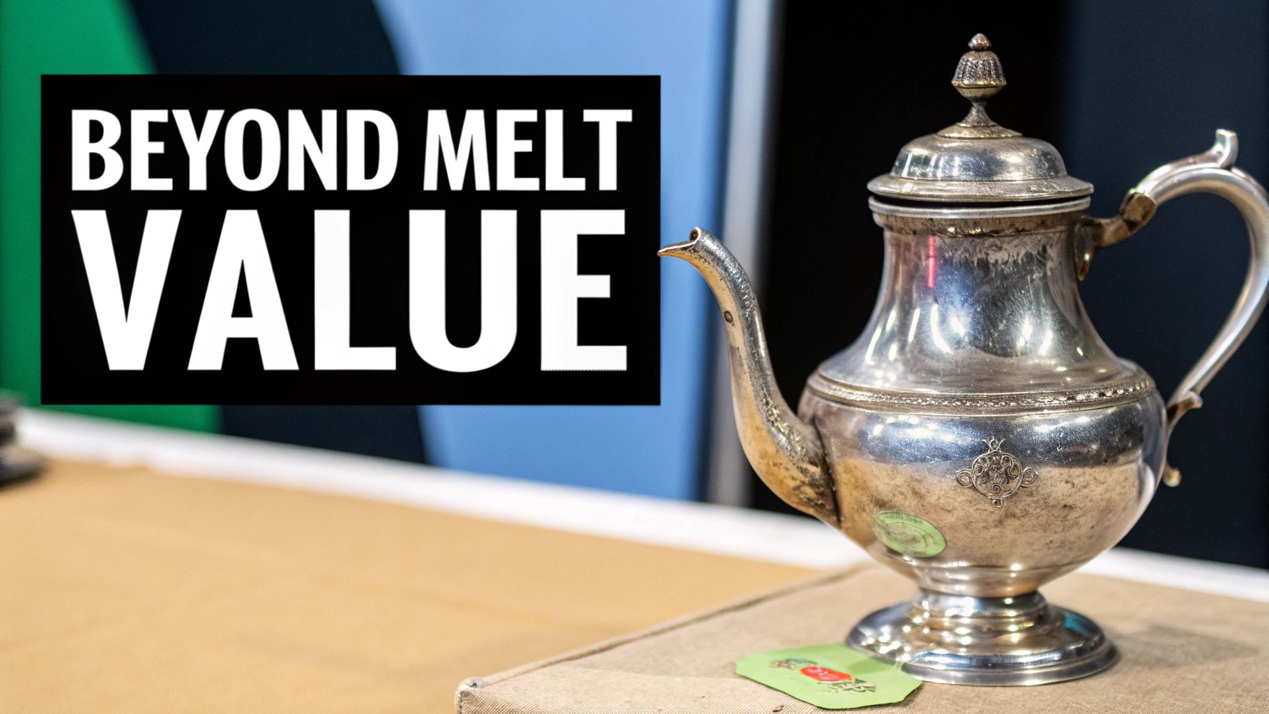 A vintage silver teapot with ornate details on a table, with a 'BEYOND MELT VALUE' sign.
