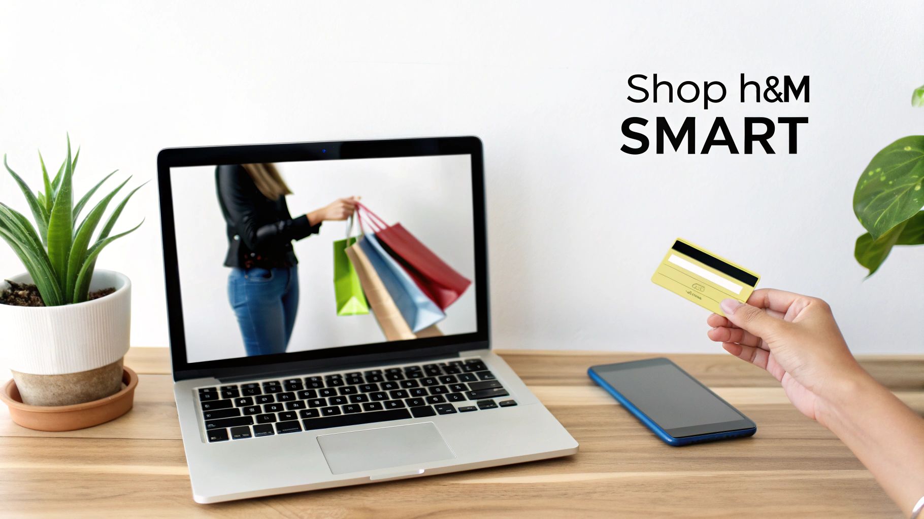 A hand holds a credit card next to a laptop displaying online shopping bags and a smartphone.
