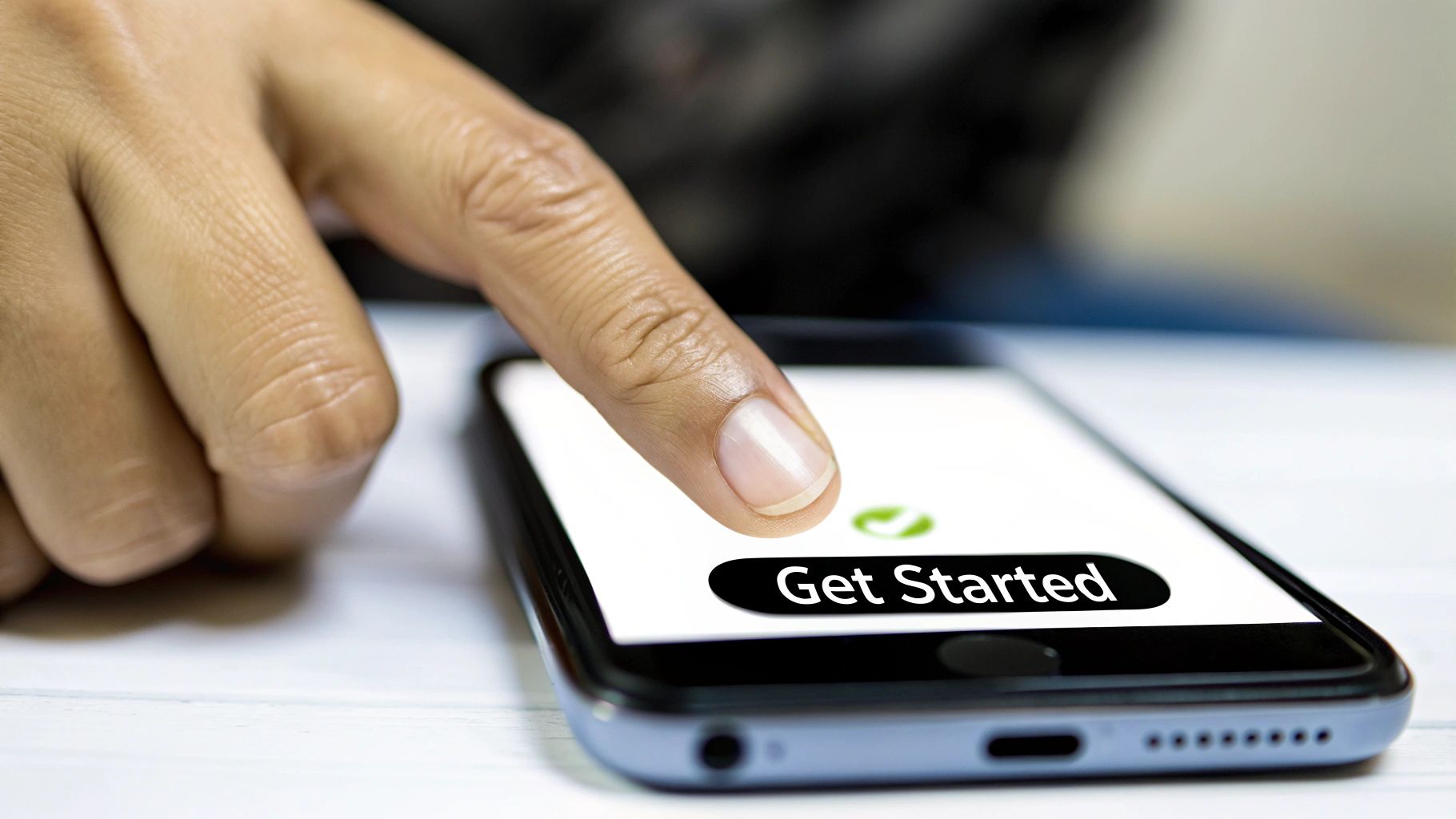 A finger taps a smartphone screen displaying a 'Get Started' button with a green checkmark.