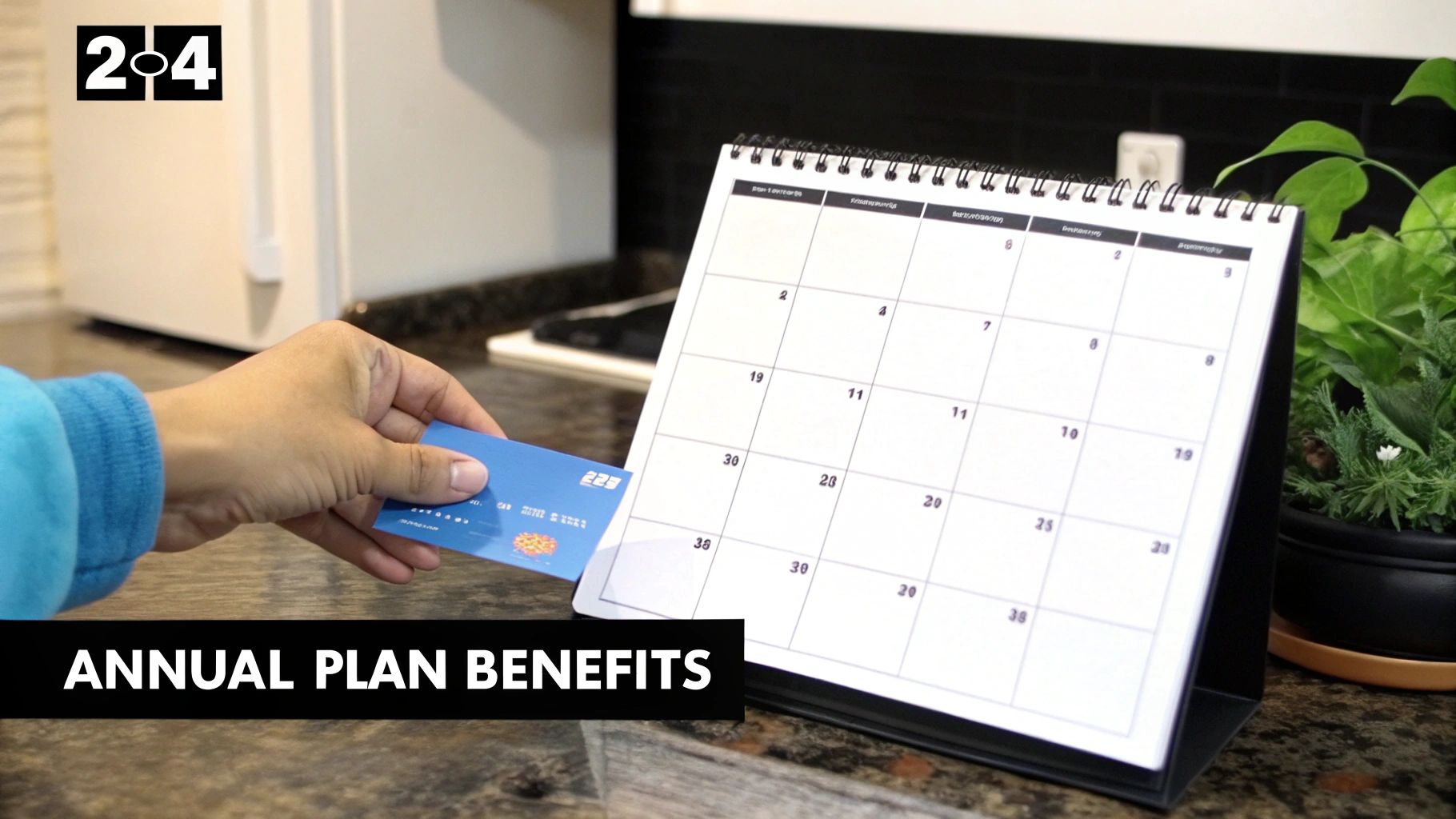 A hand holds a blue credit card near a desk calendar, showing annual plan benefits.