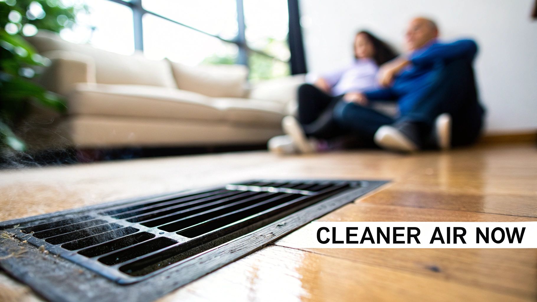 A floor vent releasing smoke or dust, with a blurred couple in the background, implying home air quality.
