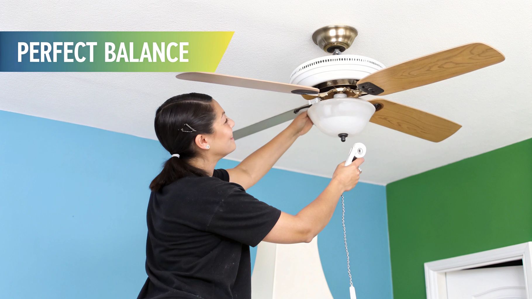 A close-up shot of a person using a balancing kit clip on a ceiling fan blade.