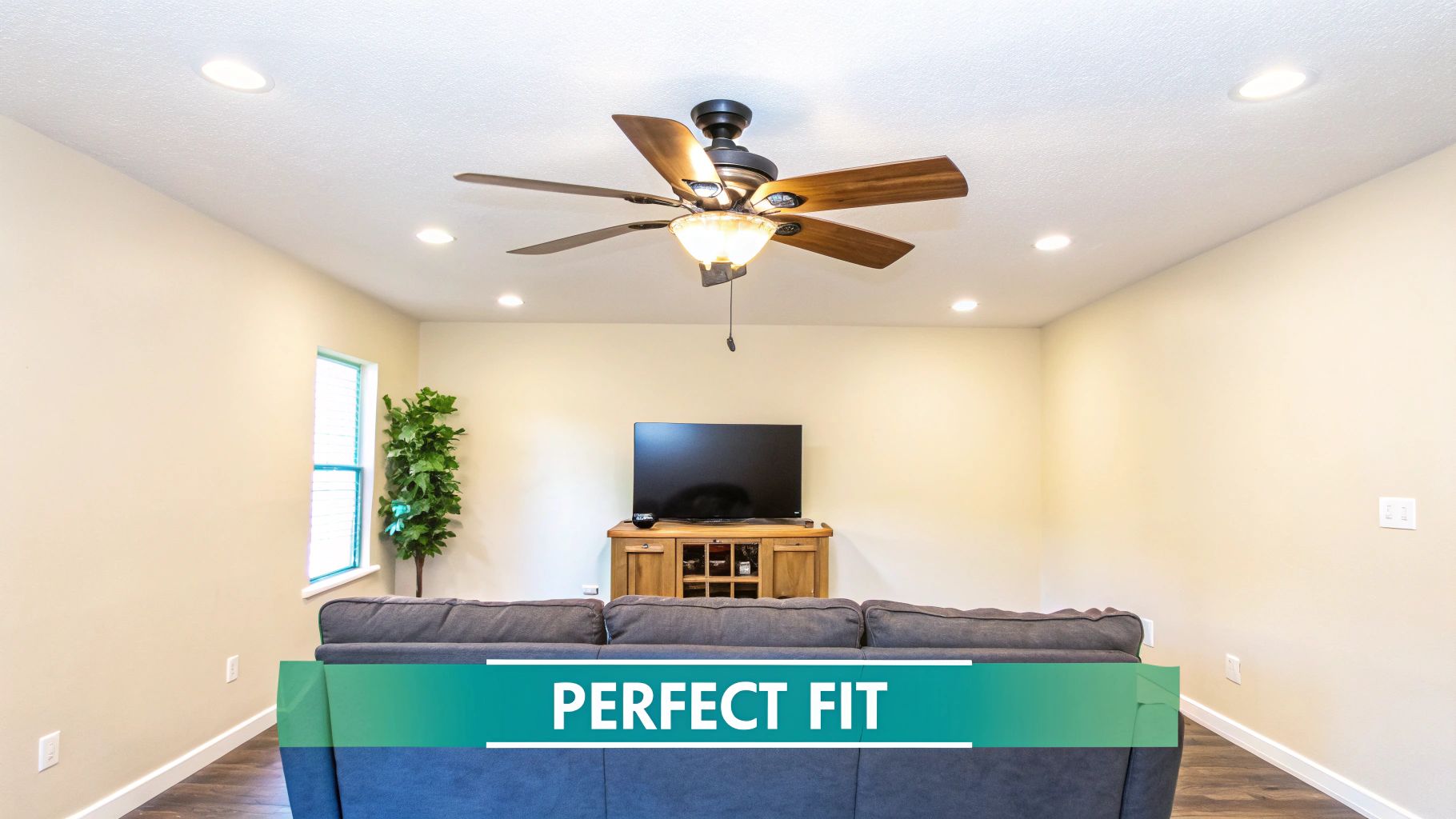 A modern living room featuring a ceiling fan, recessed lighting, a television setup, and a sofa.