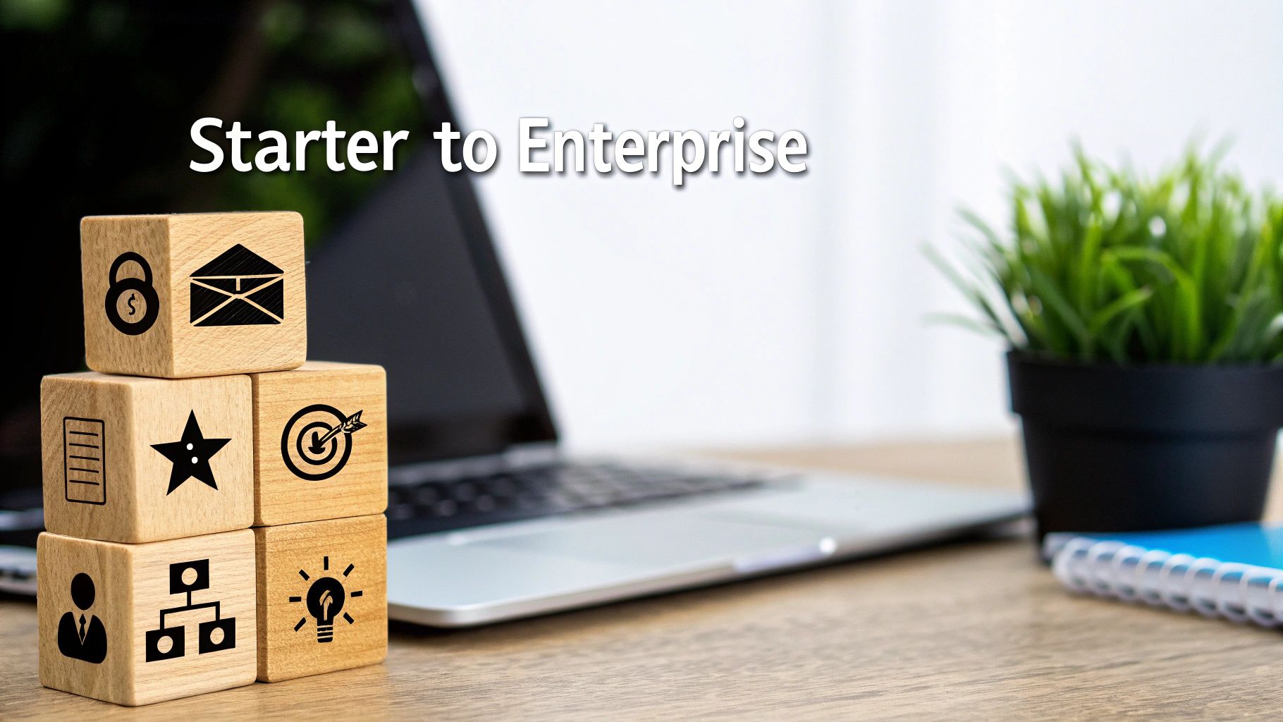 Wooden blocks with business icons, a laptop, and the text 'Starter to Enterprise' on a desk.