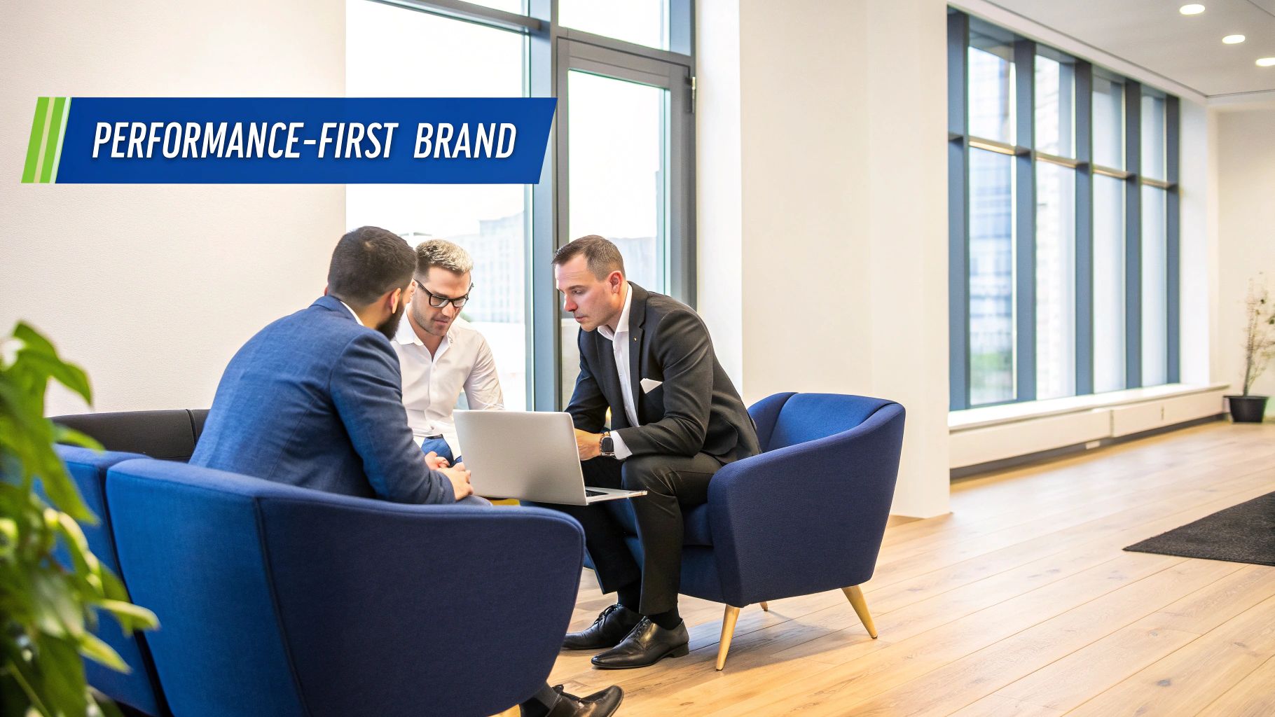 Three businessmen discussing work on a laptop in a modern office lounge with a brand banner.