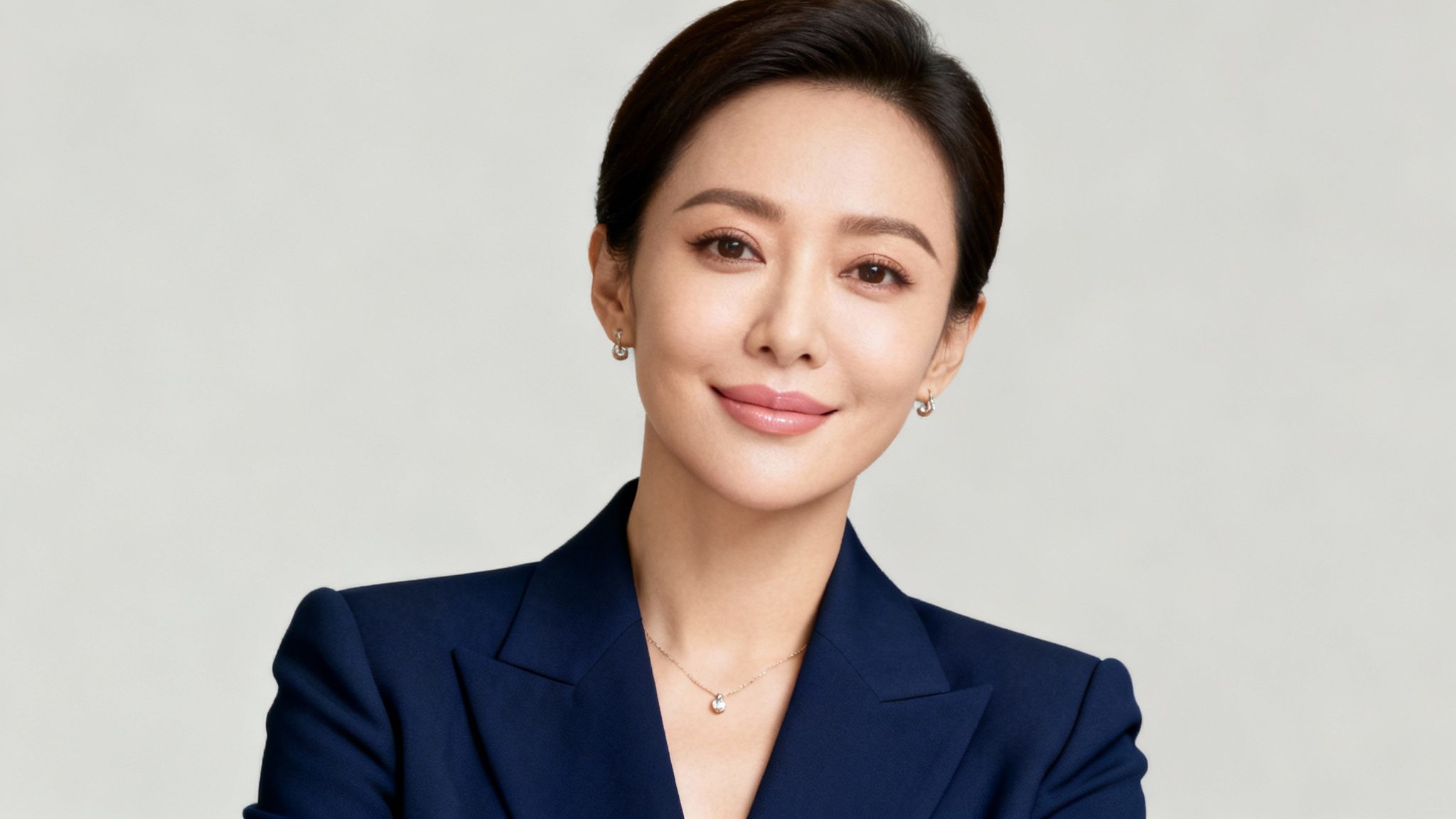 The 8 Best Colors to Wear on Camera in 2025 1 Professional Asian woman in navy blue blazer smiling at camera in business portrait