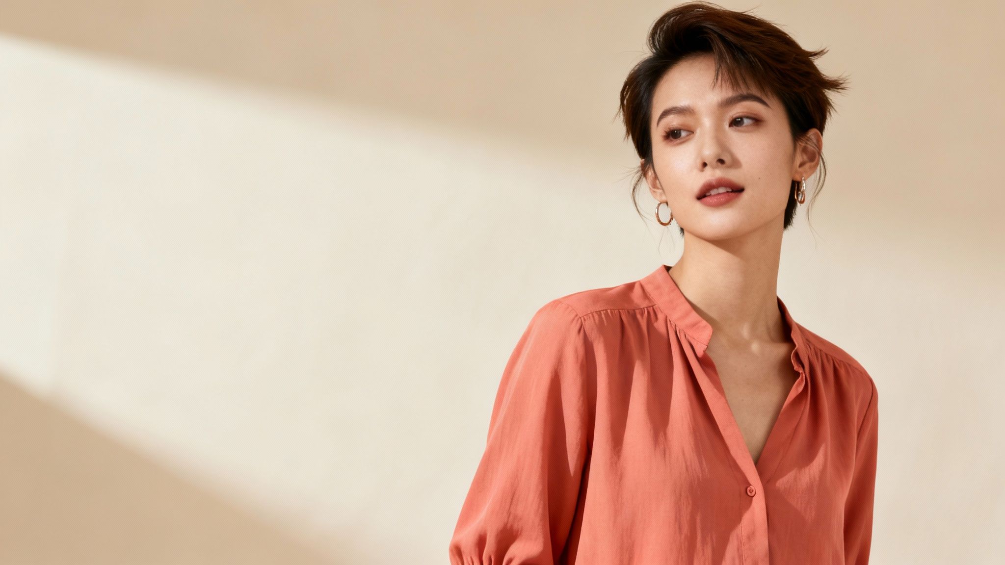 The 8 Best Colors to Wear on Camera in 2025 9 Woman wearing coral peach blouse with natural makeup against neutral beige background for camera