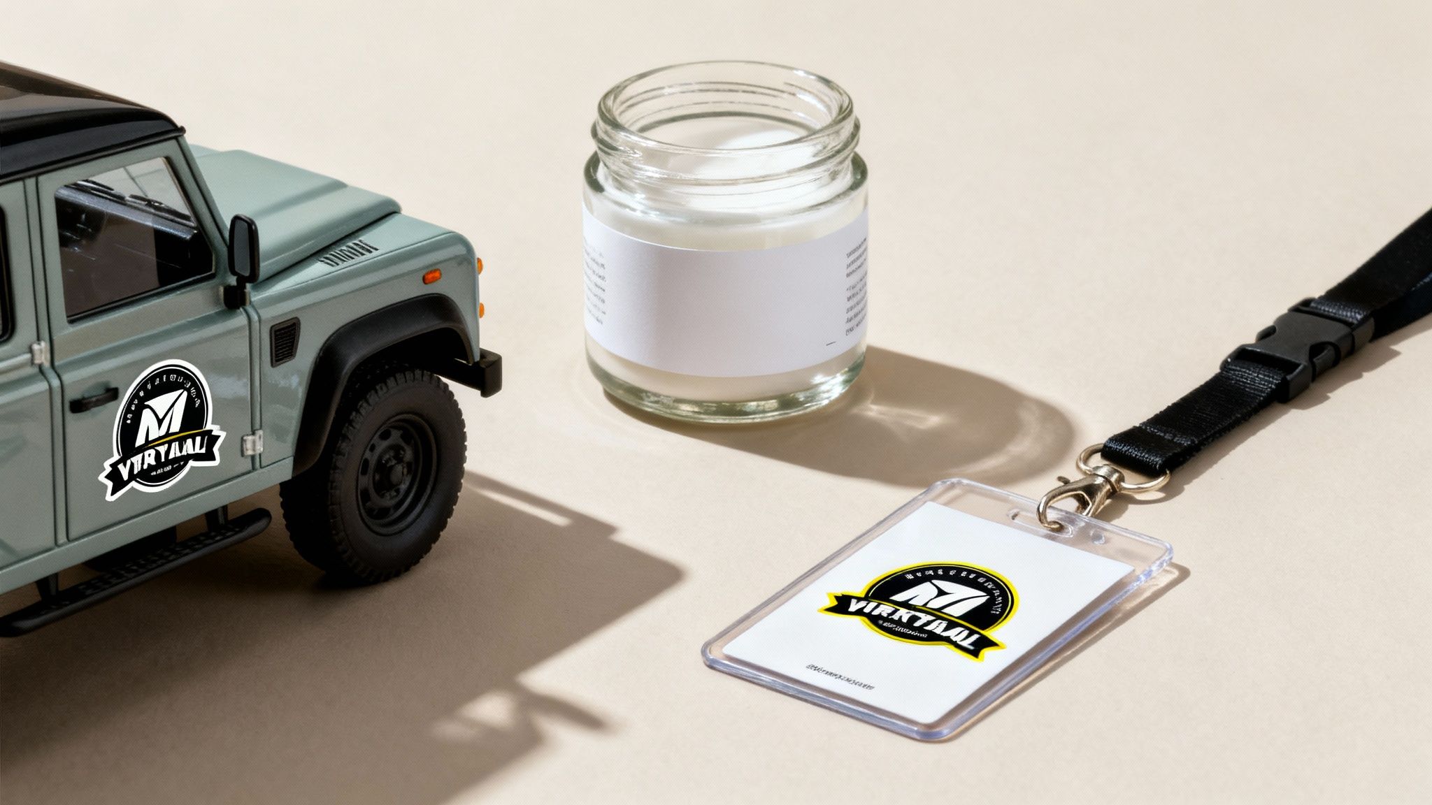 A toy Land Rover, a jar, and a lanyard with a Virktaal logo sticker, showcasing branding.