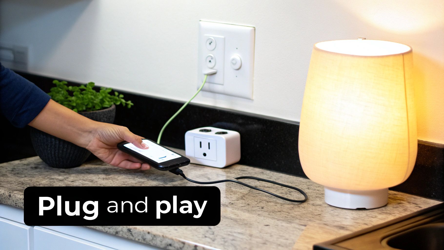 A person plugs a smartphone into a white smart power outlet hub on a kitchen counter, next to a glowing lamp.