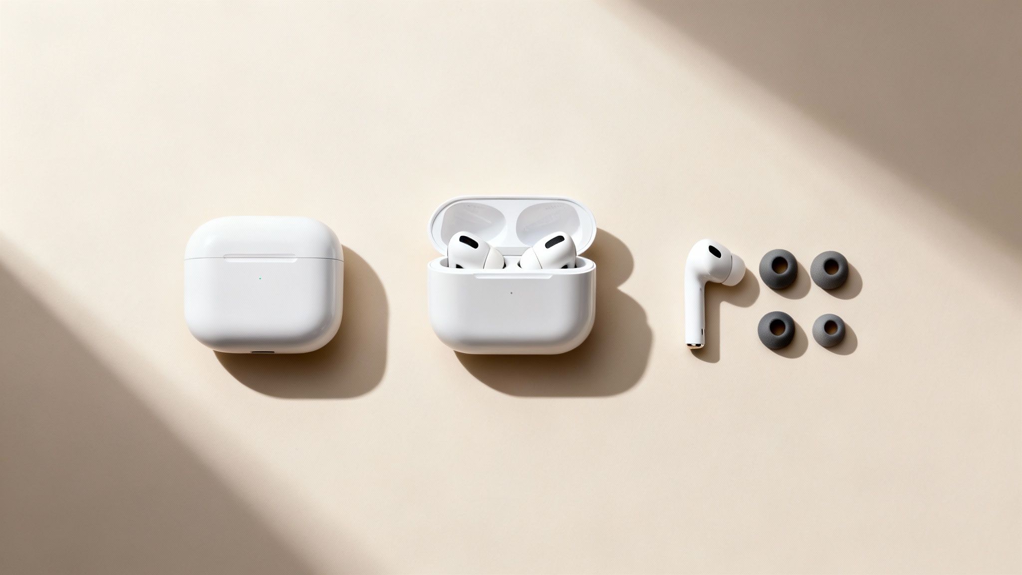 Three white Apple AirPods Pro cases and earbuds with ear tips displayed on a beige surface.