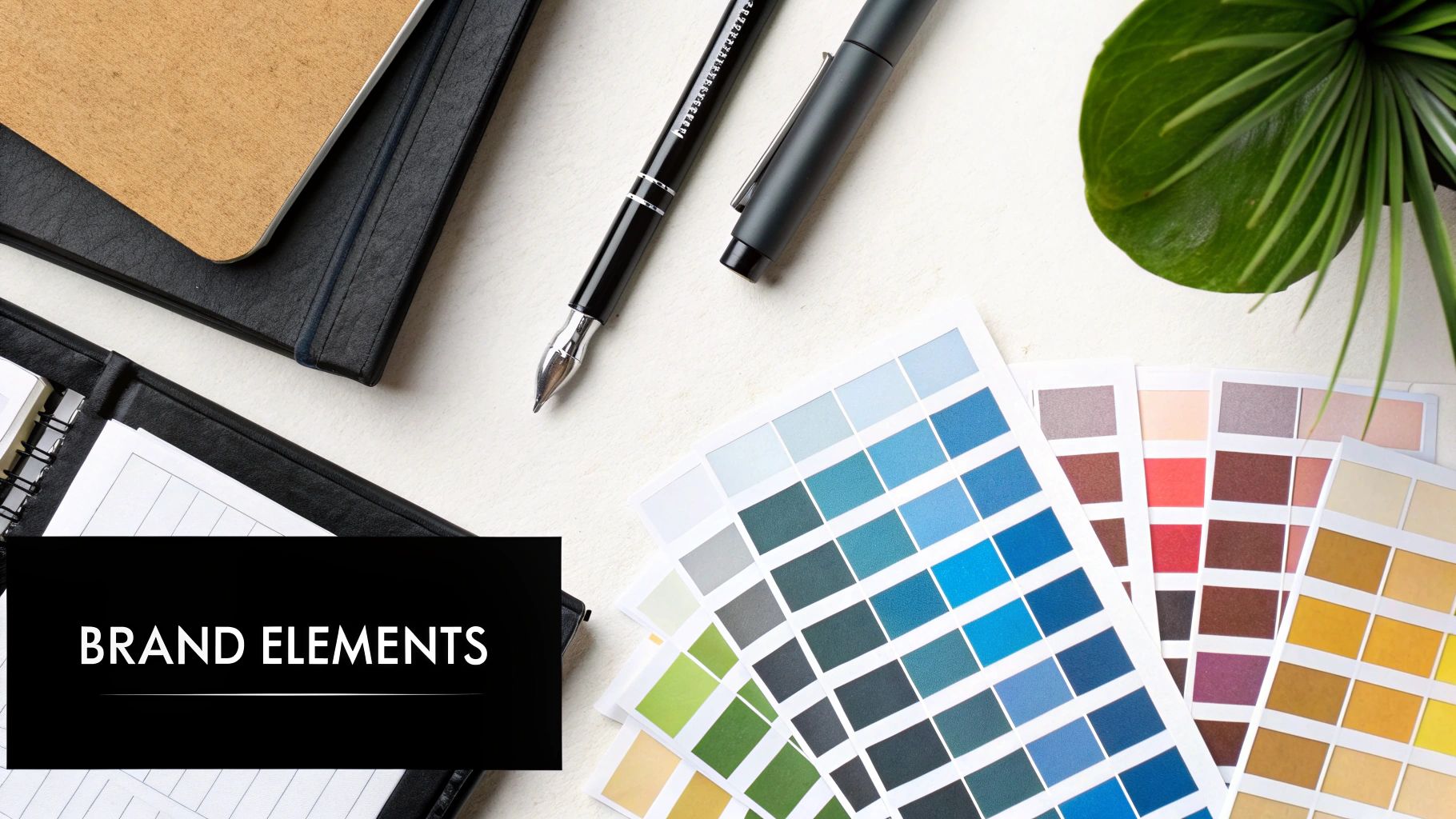 A desk with branding materials including a colour palette and logo designs, representing a style guide in development.