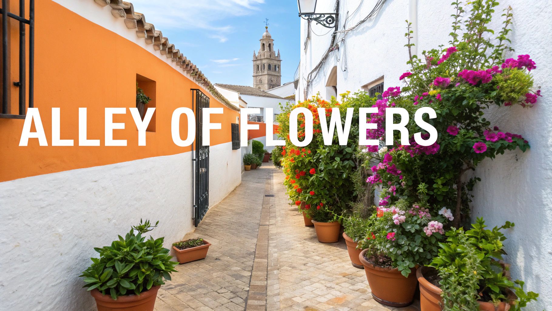 A vibrant Spanish alleyway adorned with potted flowers, leading towards a historic tower under a clear sky.