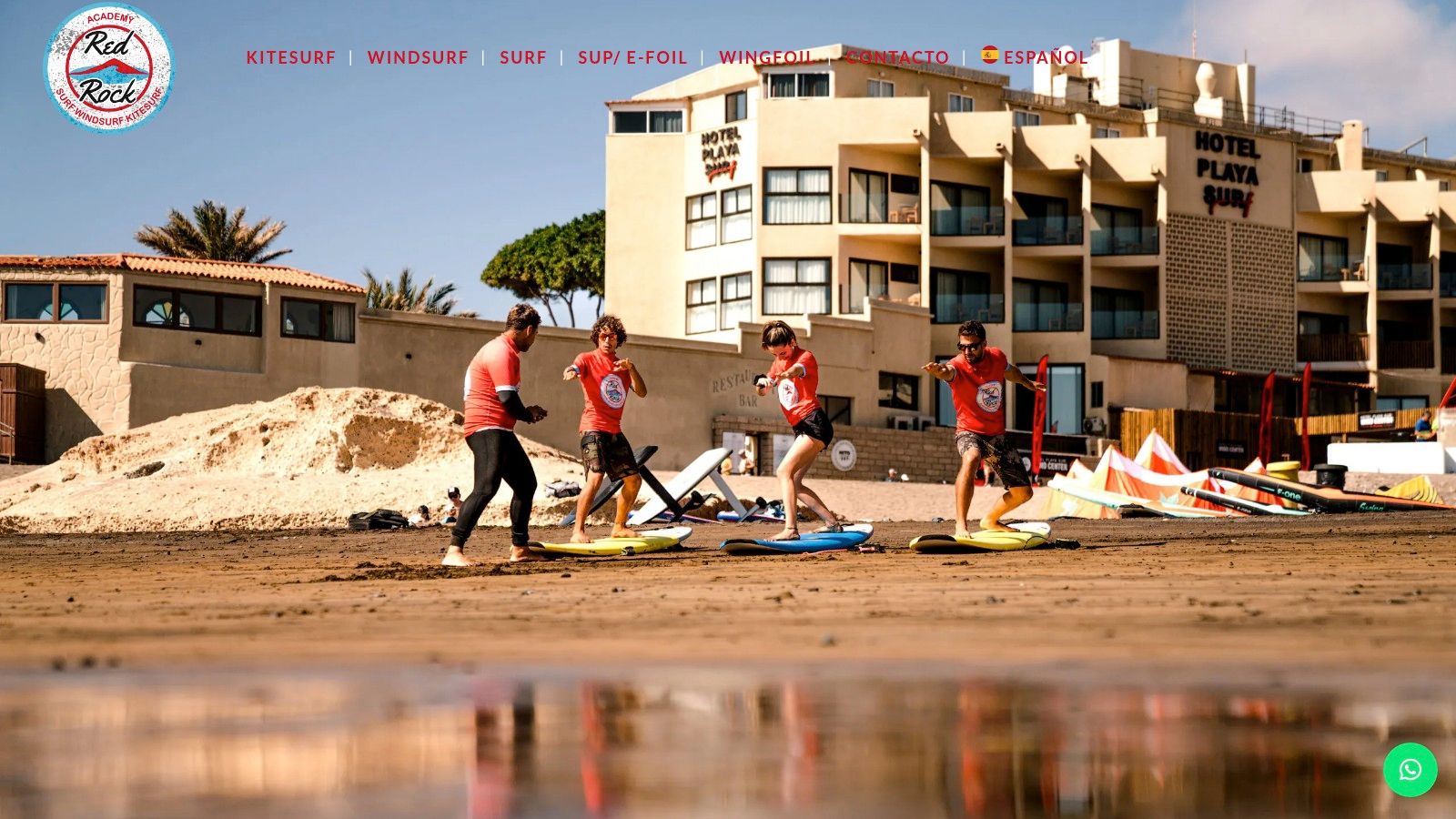 A group of surfers learning on the beach at Red Rock Surf & Kite Academy in El Médano, Tenerife