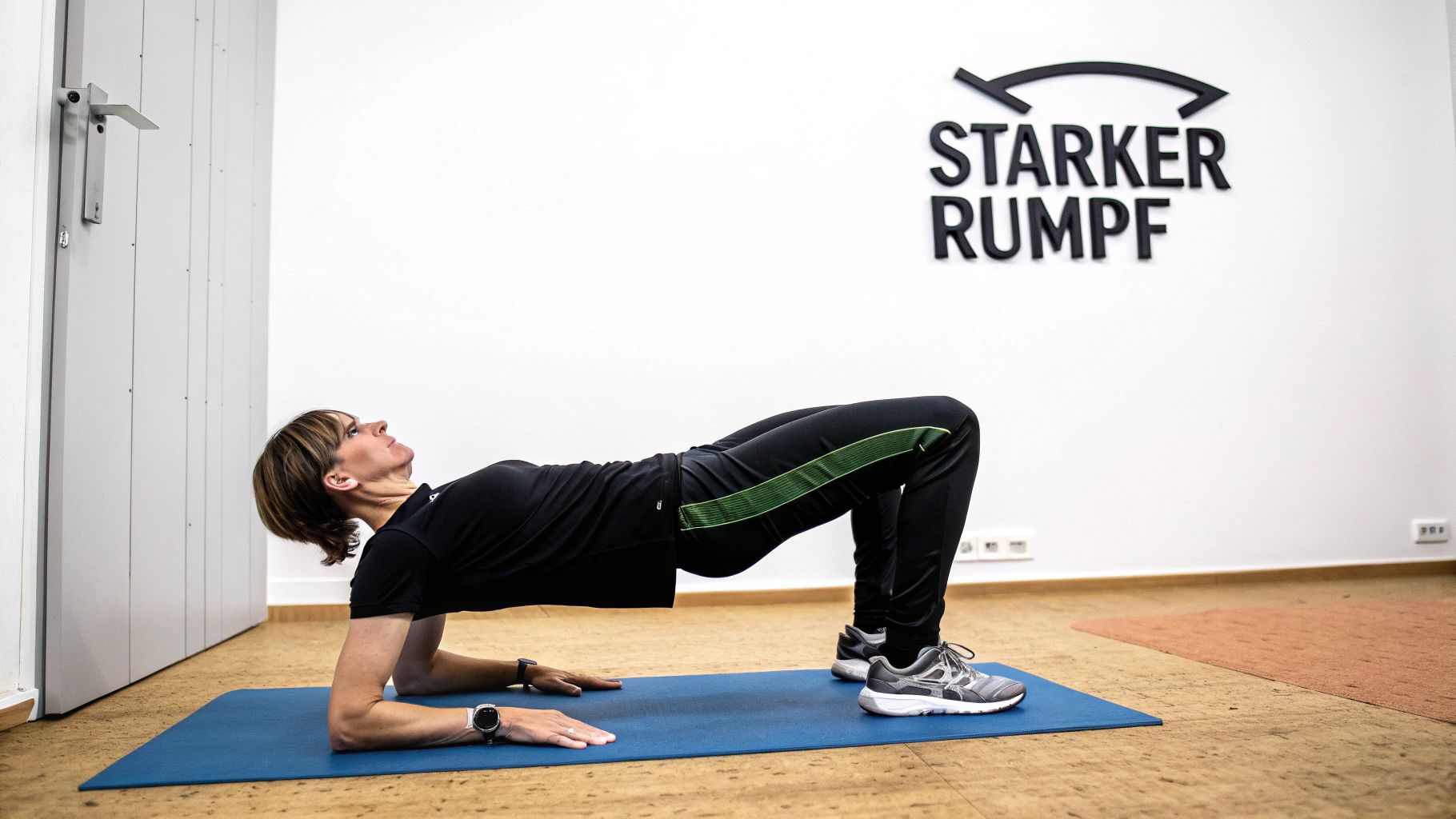 Eine Frau macht eine Brückenübung auf einer blauen Matte, um ihren Rumpf zu stärken.