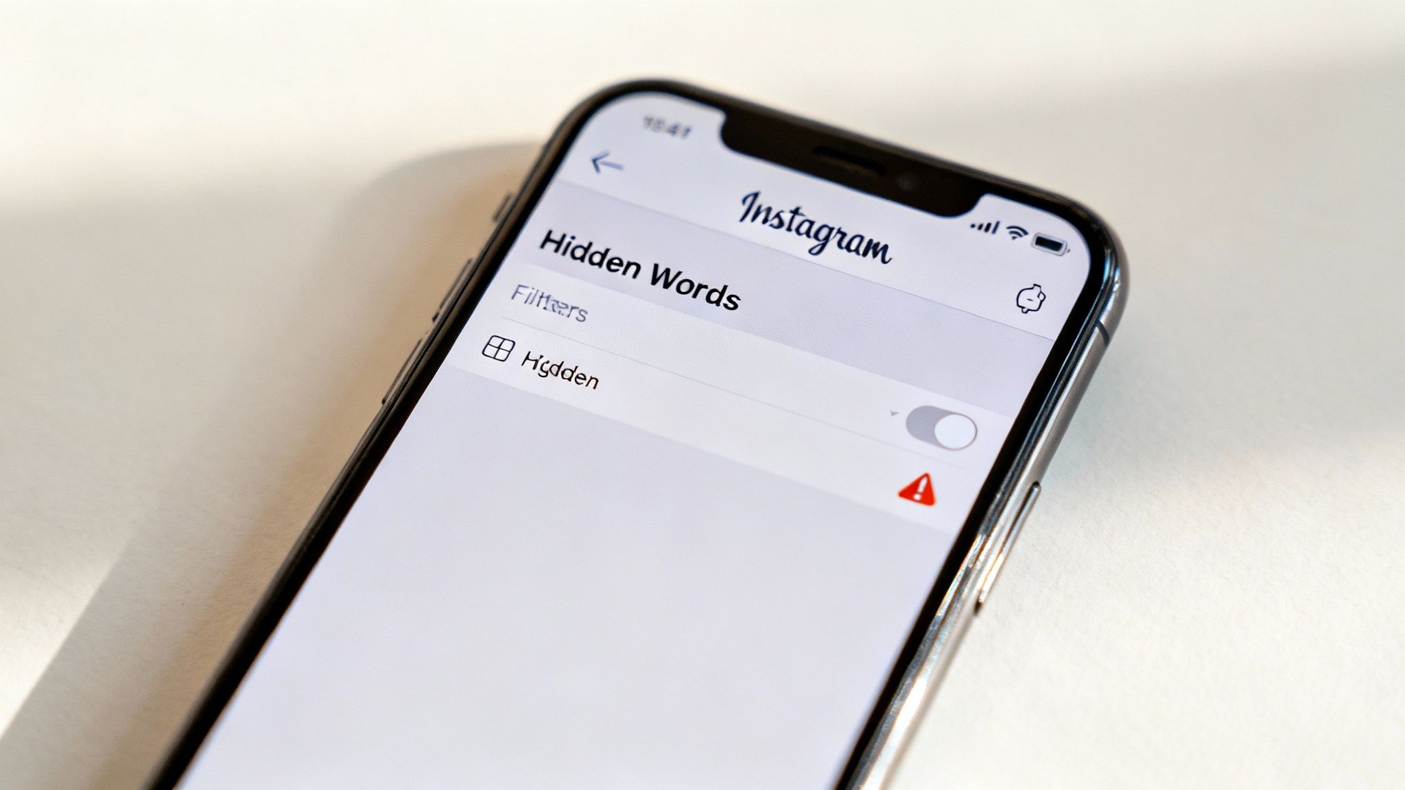 Close-up of an iPhone screen showing Instagram's 'Hidden Words' settings with 'Hidden' filter off.