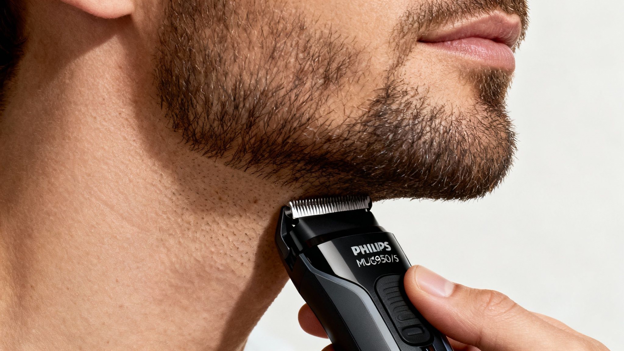 Bărbat care își aranjează barba cu un trimmer Philips