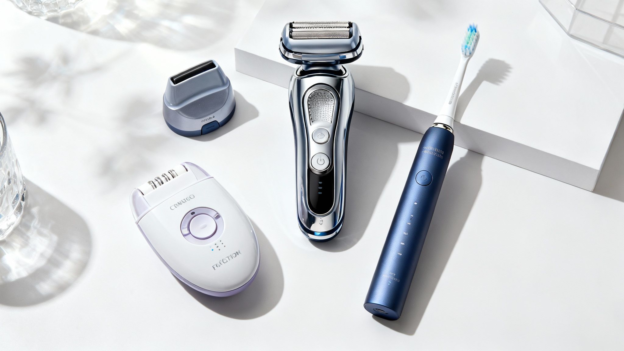 O selecție de aparate de îngrijire personală, inclusiv un aparat de ras electric și un uscător de păr, aranjate elegant pe o suprafață de marmură.