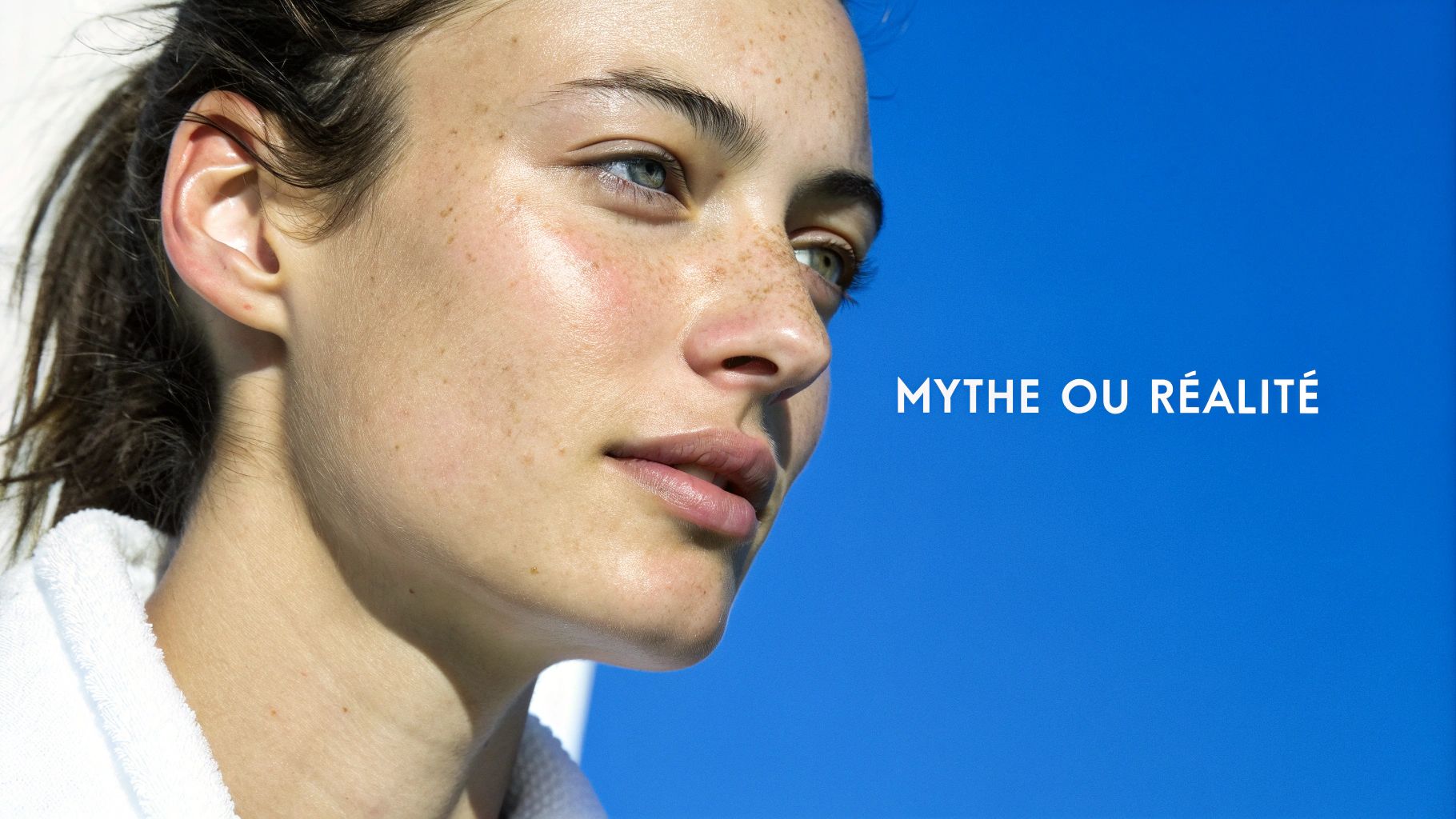Gros plan sur une jeune femme aux taches de rousseur avec texte 'Mythe ou Réalité' sur fond bleu.