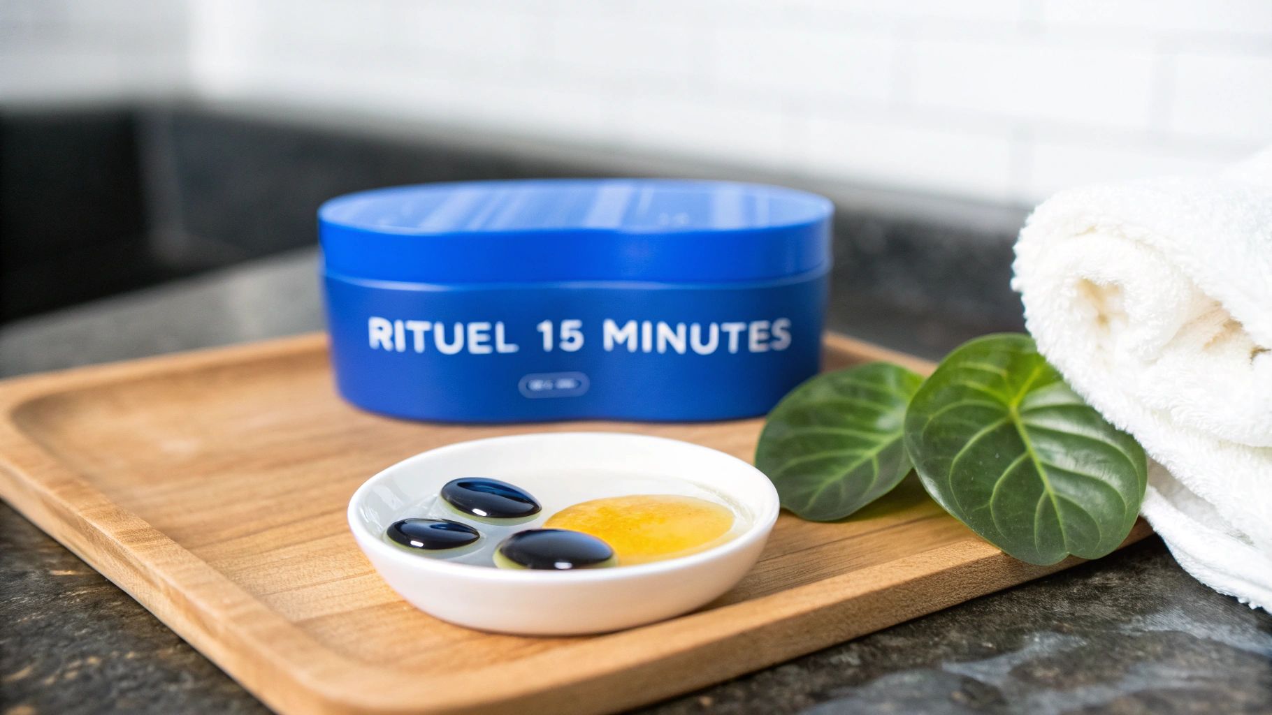 Rituel de bien-être avec un pot bleu "RITUEL 15 MINUTES", un bol d'eau, des feuilles et une serviette blanche.