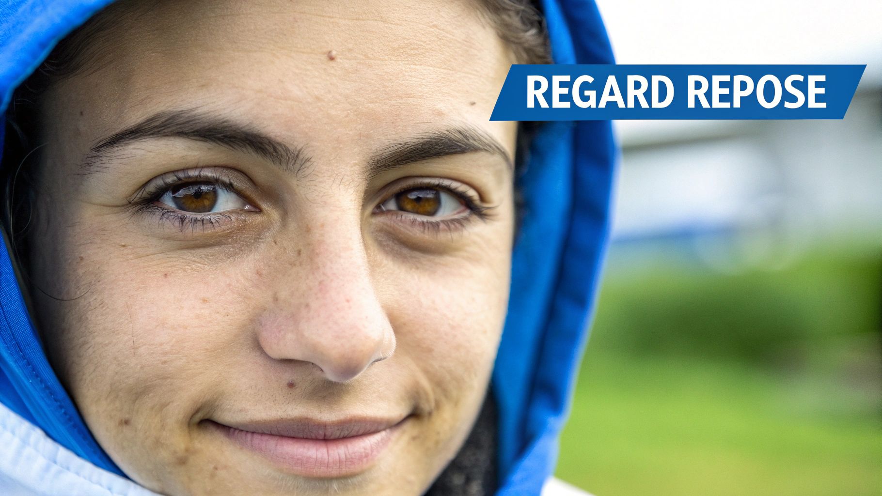 Visage souriant d'une personne aux yeux marron et capuchon bleu, avec le texte REGARD REPOSE.