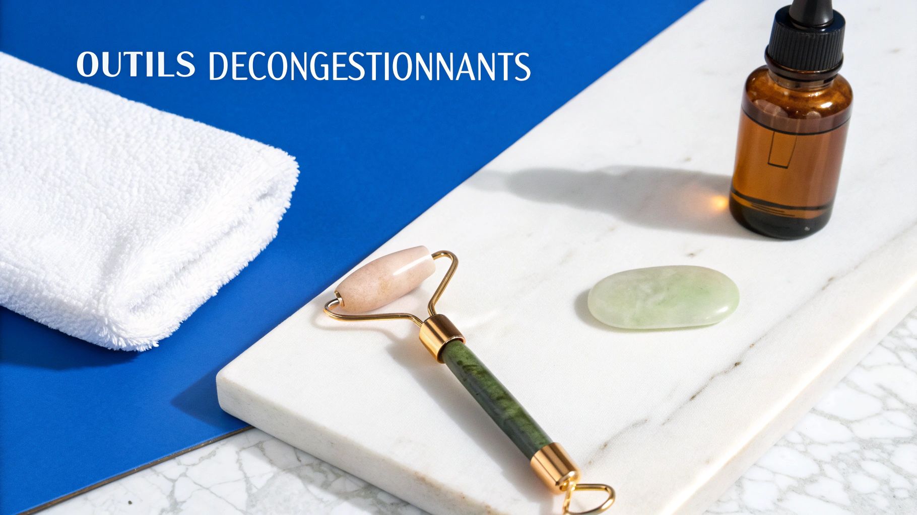 Vue de dessus d'outils de décongestion faciale sur marbre blanc, incluant un rouleau de jade, une pierre gua sha et une huile.