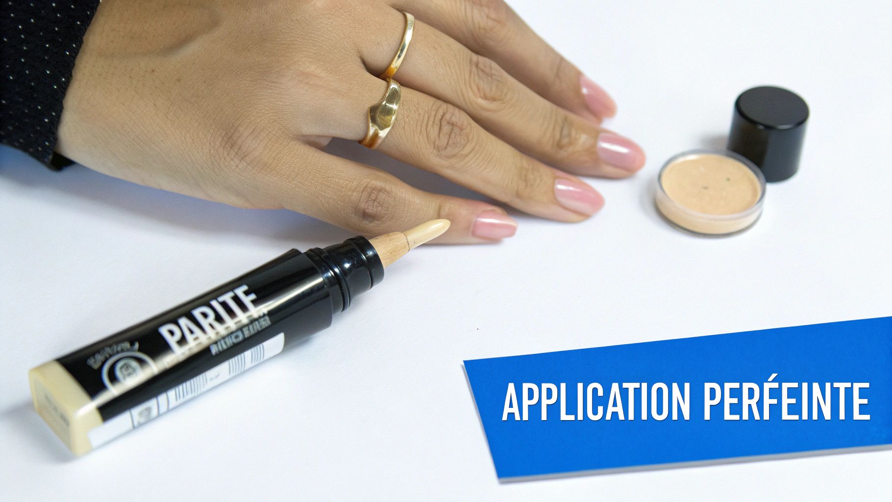 Main appliquant un anti-cernes avec un stylo et un pot de poudre, pour une application parfaite.