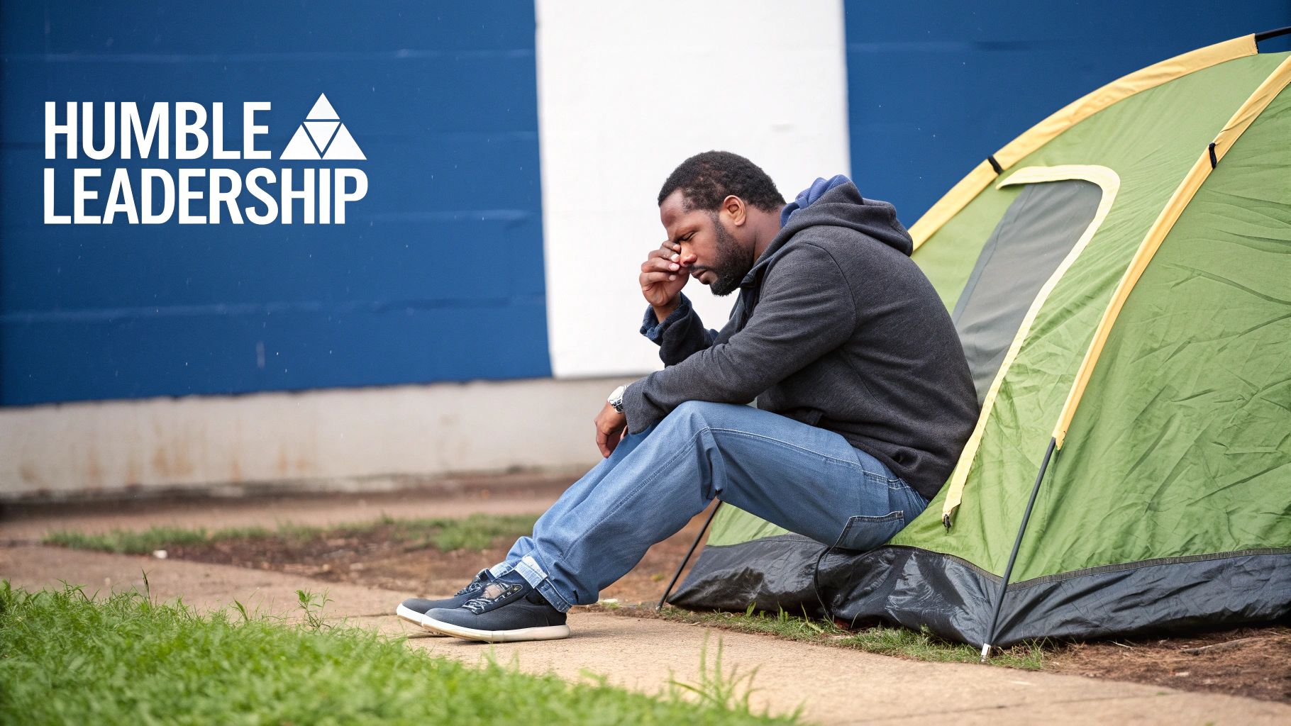 A distressed man sits by a green tent with 'HUMBLE LEADERSHIP' text, conveying struggle.