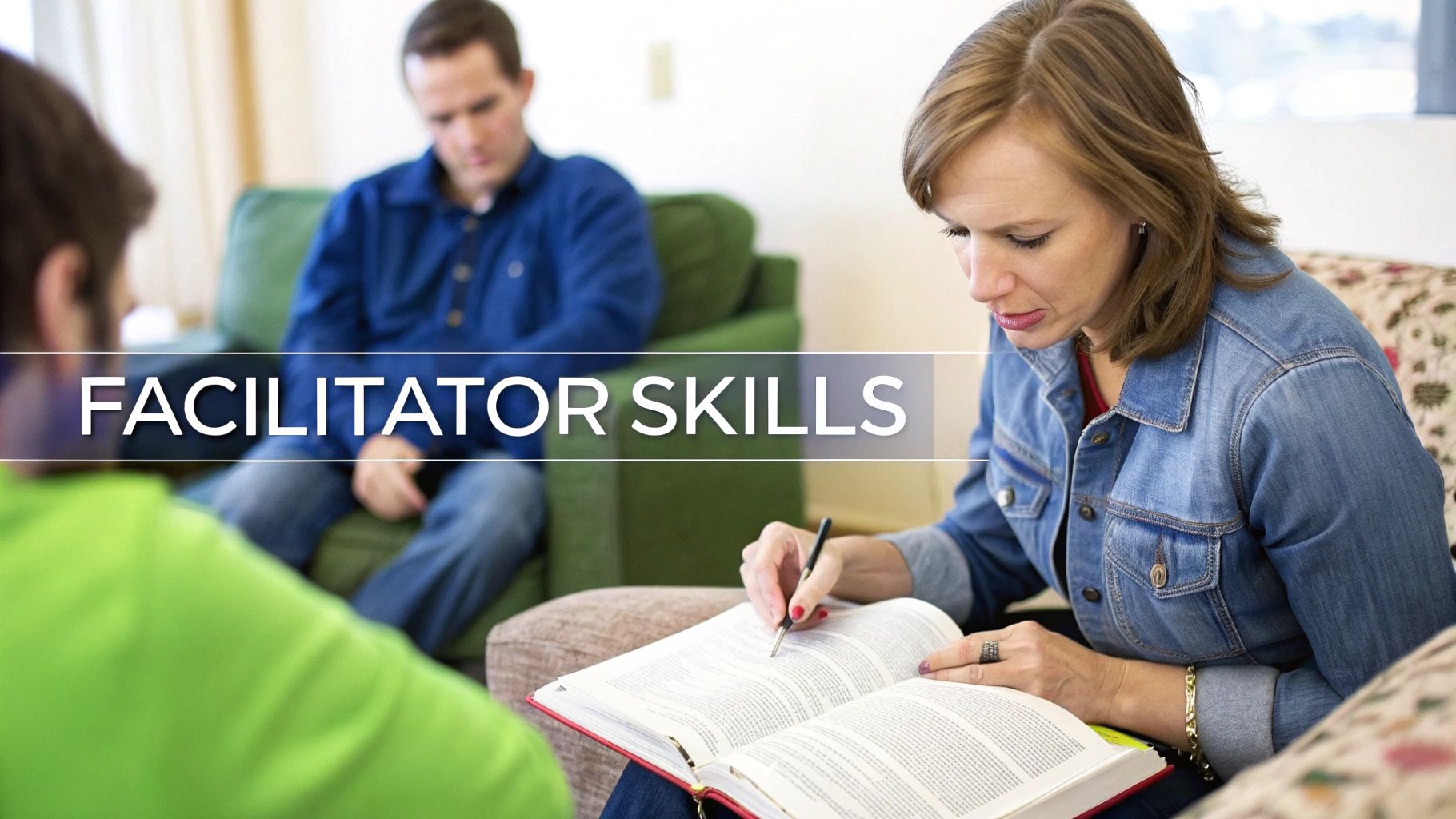 A woman in a denim jacket writes in a book during a small group study session.
