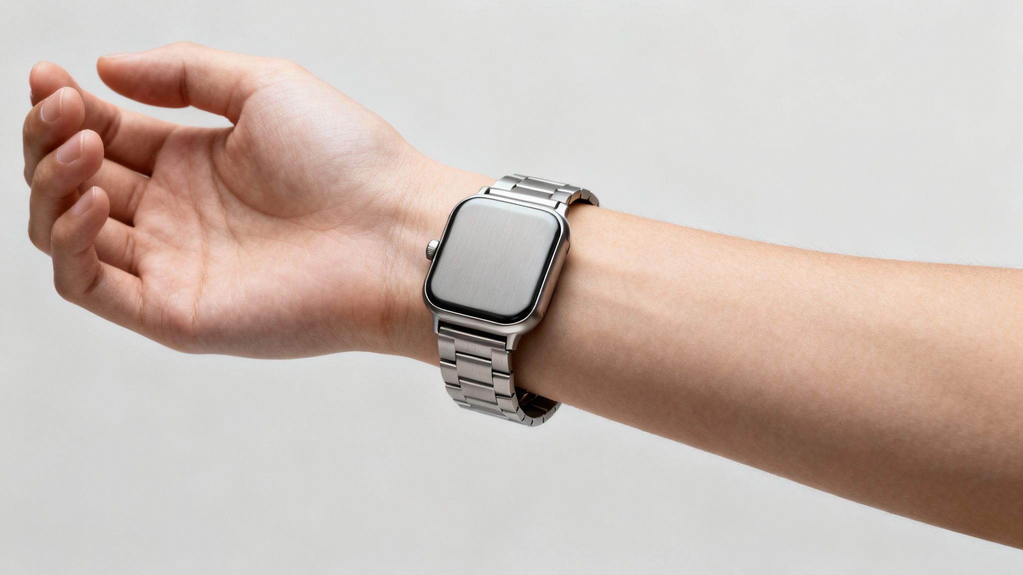 A person's wrist wearing a silver smartwatch with a metallic link band.