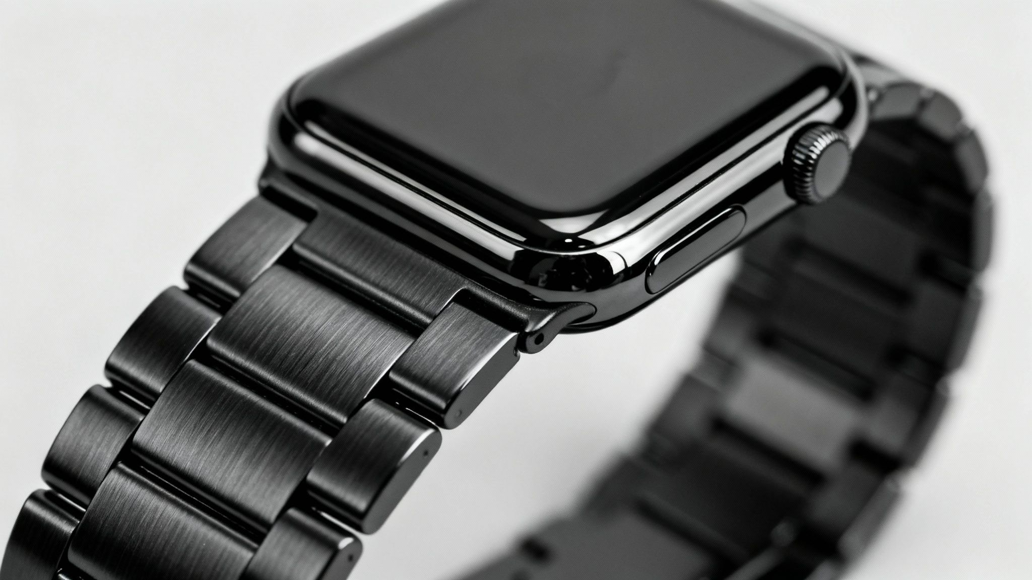 Close-up of a dark grey or black Apple Watch with a textured metal link band.
