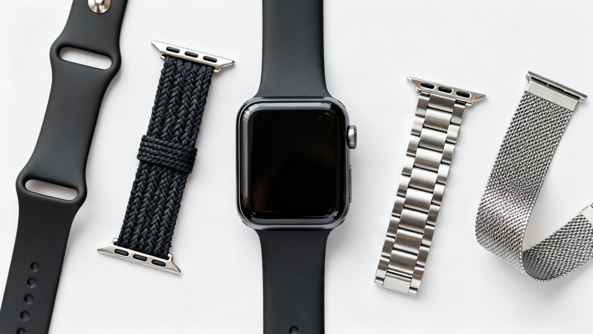 Top-down view of a black Apple Watch surrounded by various interchangeable bands.