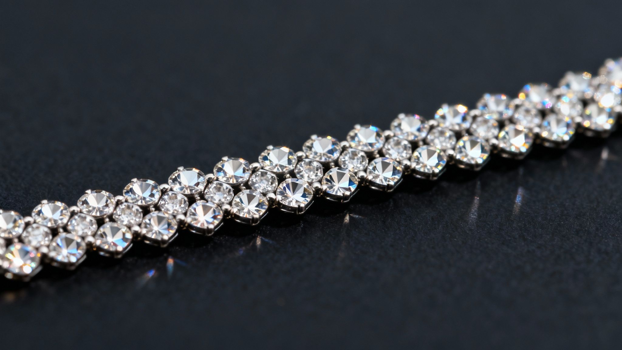 Elegant silver-toned tennis bracelet with two rows of brilliant clear crystals on a dark surface.