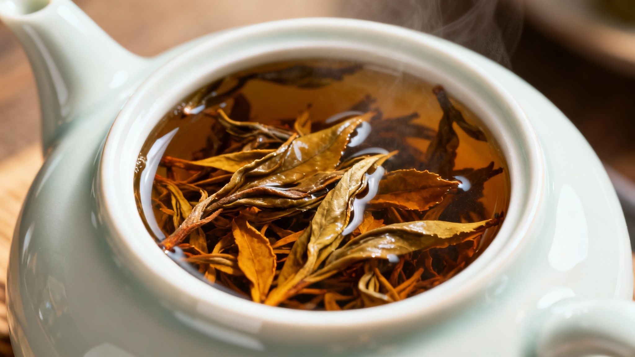 A scoop of loose leaf tea being poured into a small white bowl.