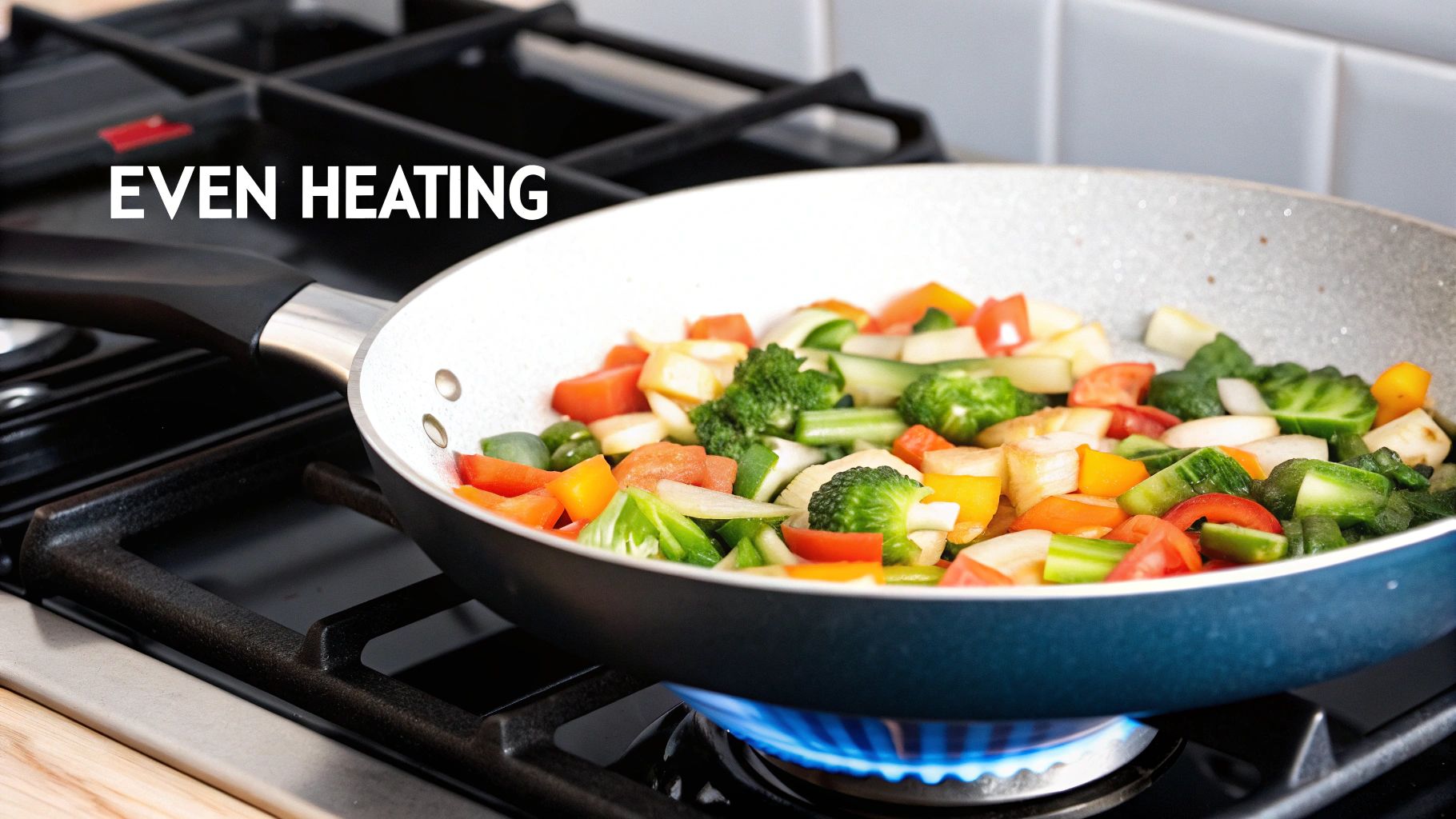 A close-up of a titanium frying pan being used to cook vegetables