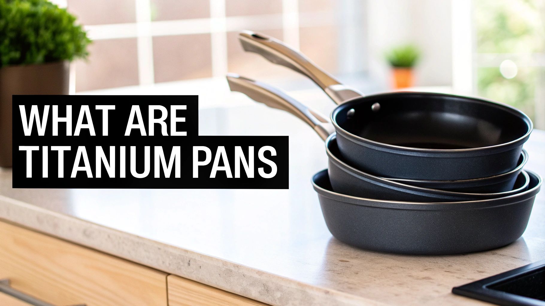 Stack of three black non-stick titanium pans on a modern kitchen countertop.