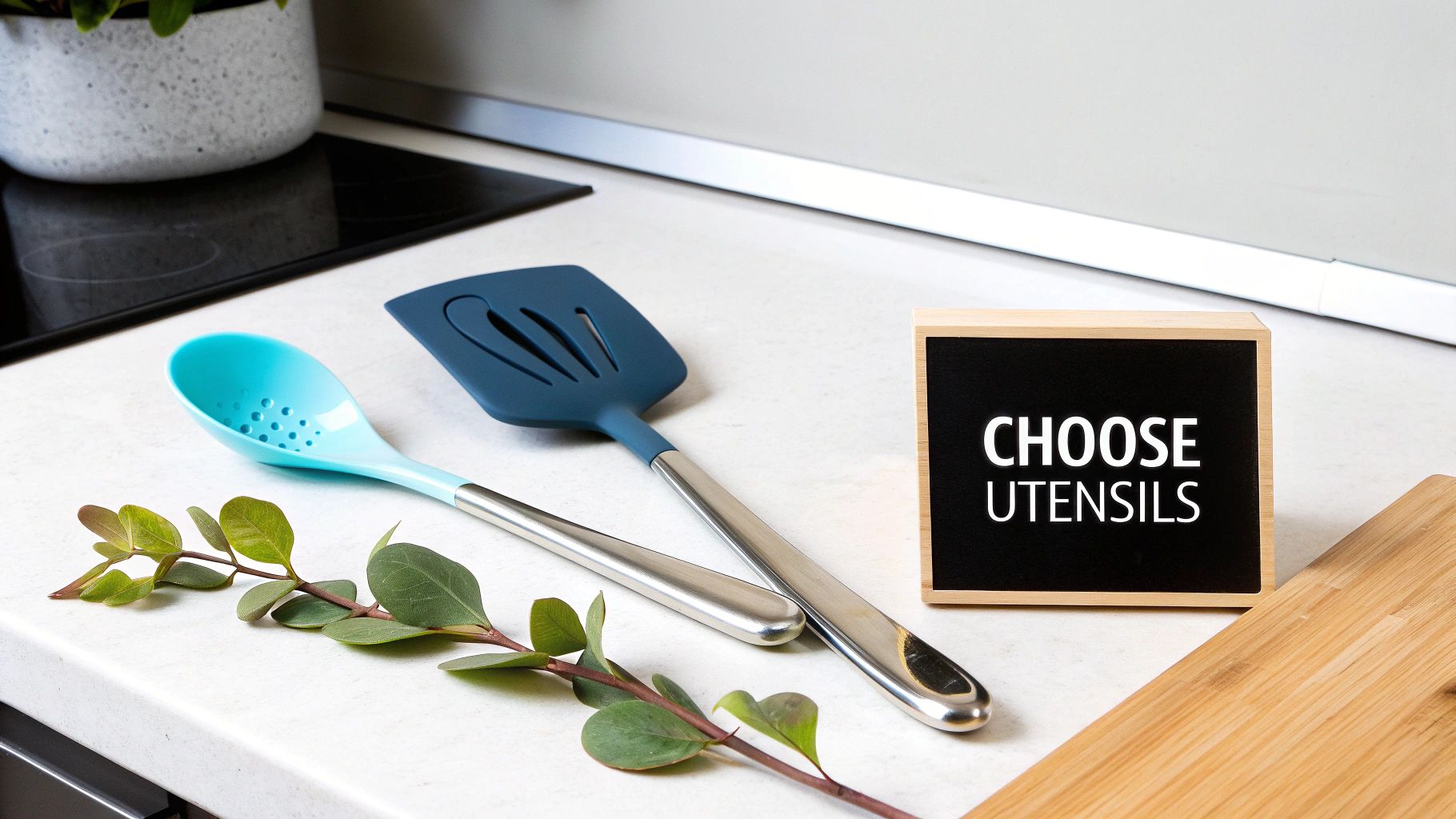 Two silicone kitchen utensils, a spoon and spatula, next to a 'CHOOSE UTENSILS' sign on a kitchen counter.