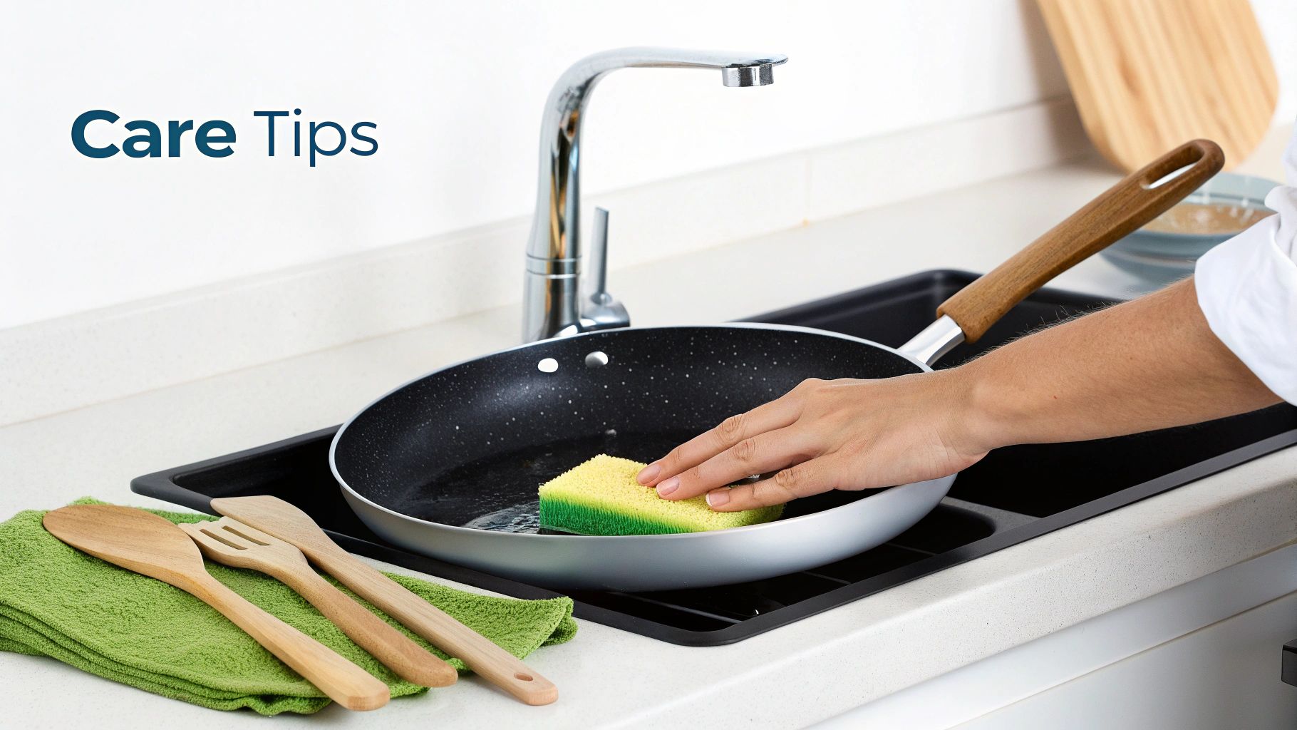 A person gently washing a titanium pan in a kitchen sink.