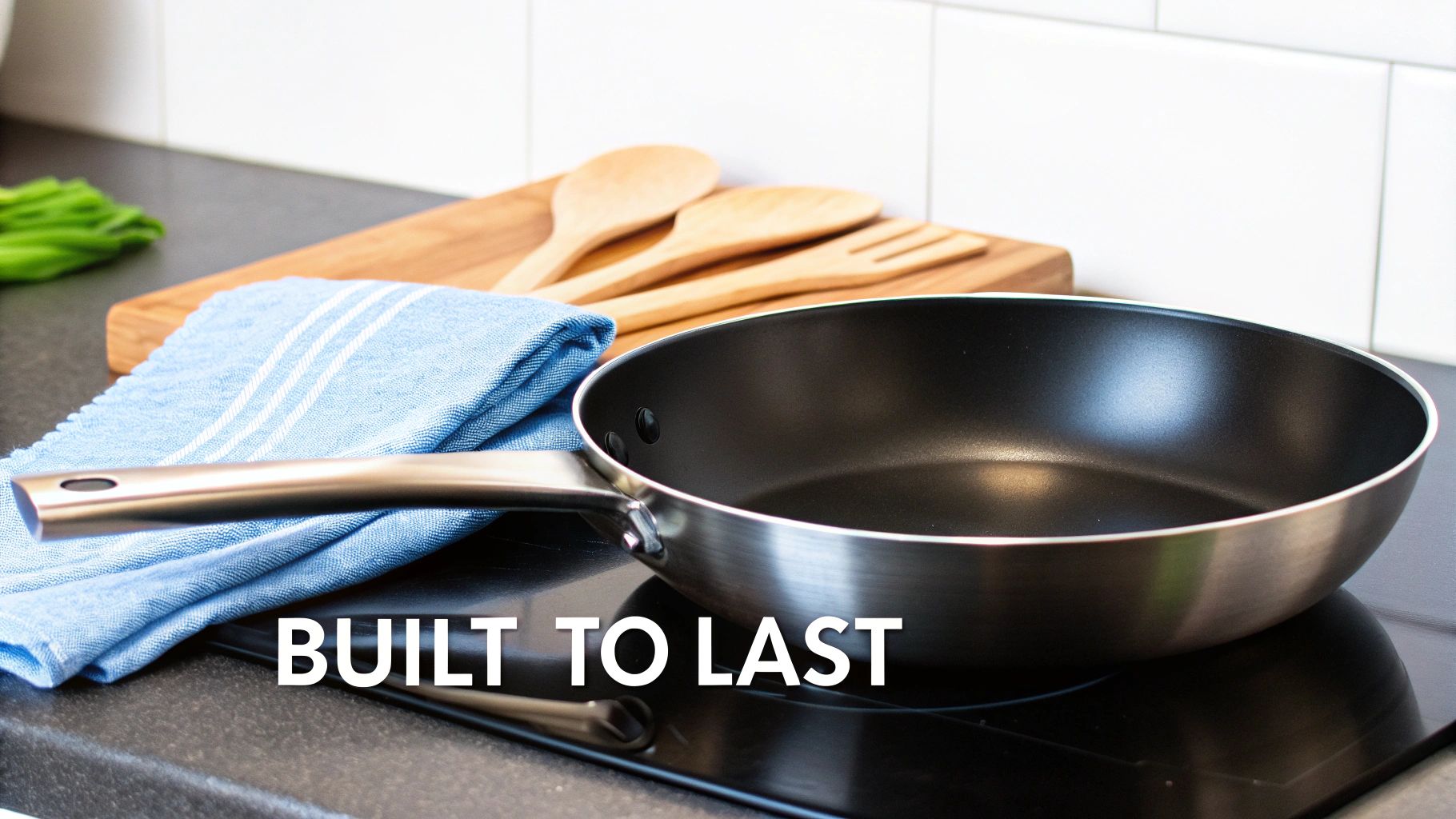 A clean, well-maintained titanium frying pan is being wiped with a soft cloth.