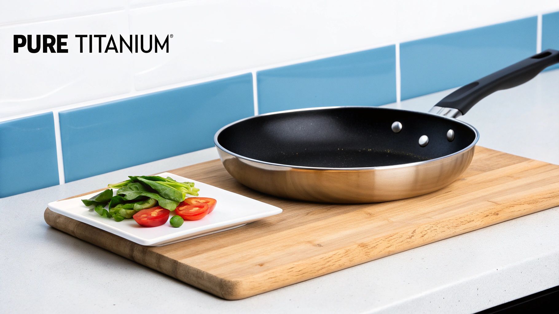 A PURE TITANIUM frying pan on a wooden board with fresh salad ingredients on a kitchen counter.