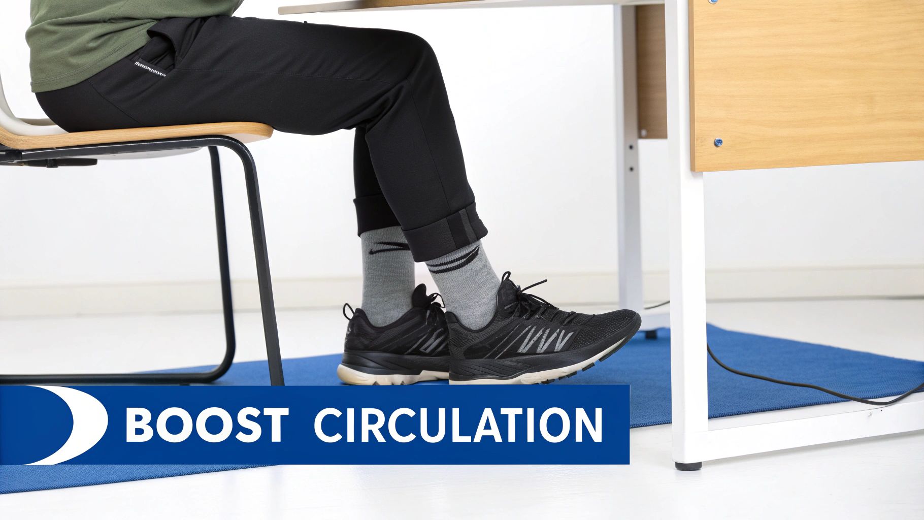 Person seated at a desk with feet on a blue mat, wearing sneakers to boost circulation.