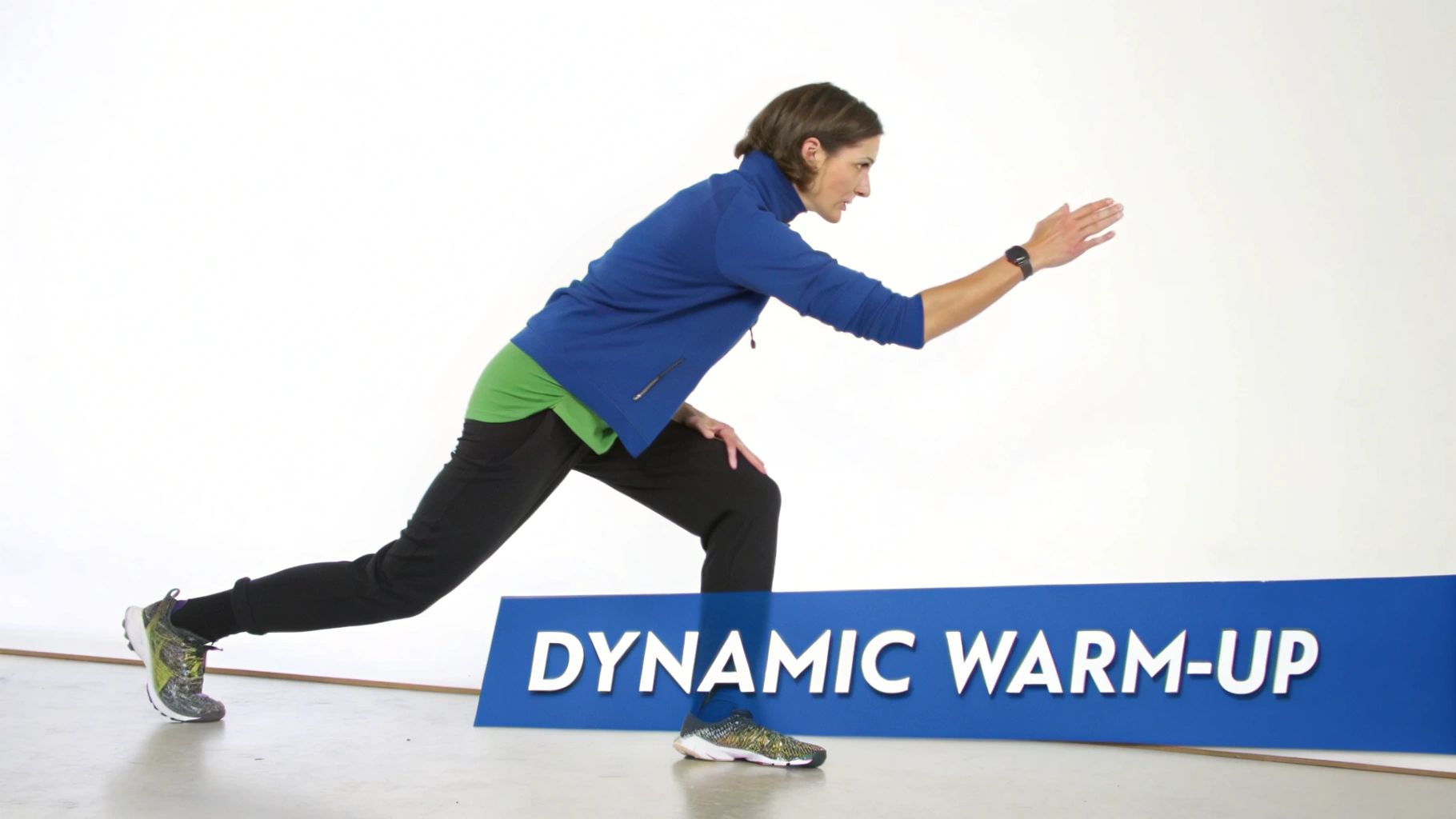 A woman in a blue jacket and black pants performs a lunge exercise for a dynamic warm-up.