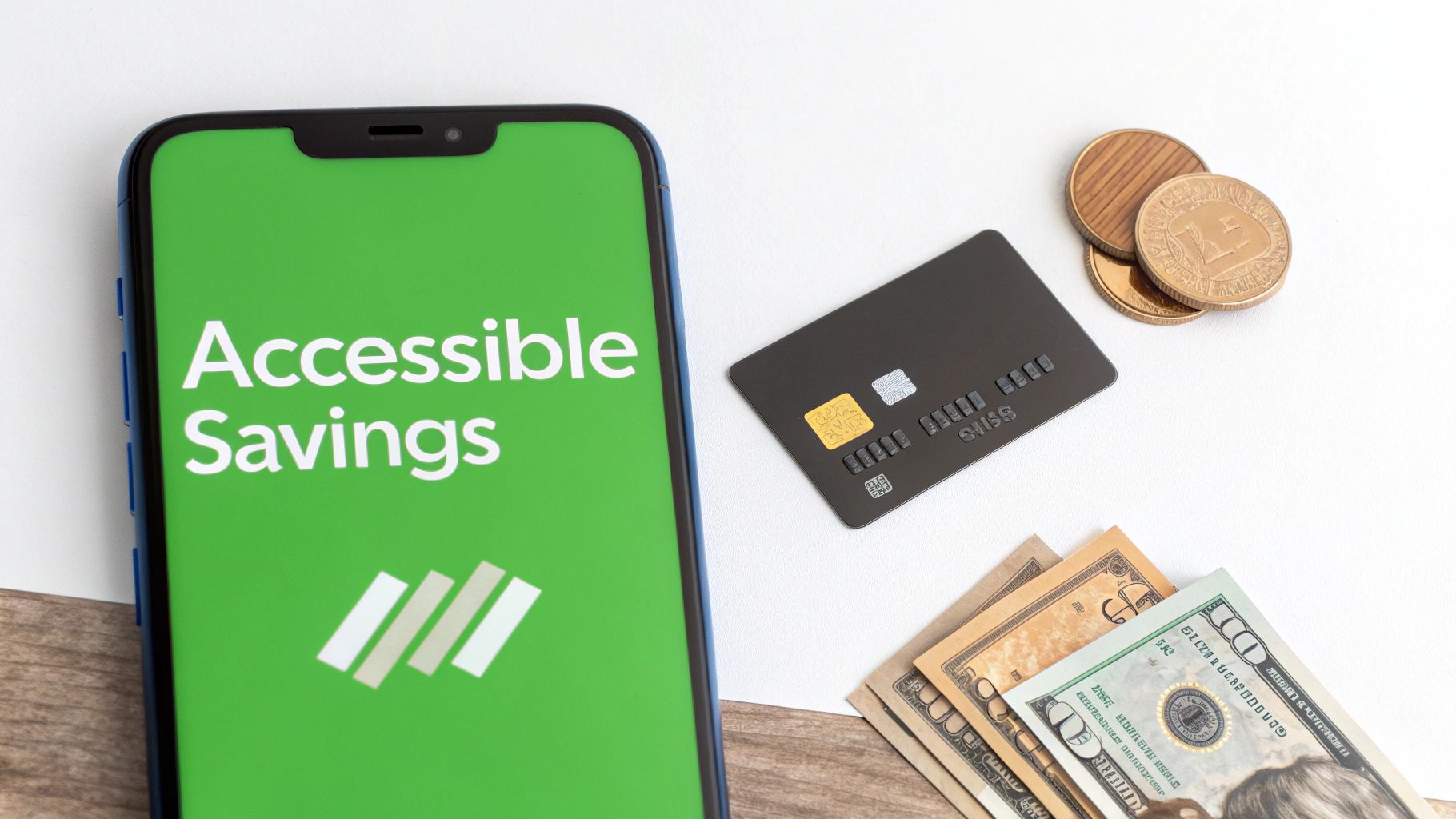 Smartphone displaying an 'Accessible Savings' app alongside a credit card, gold coins, and US dollar bills.