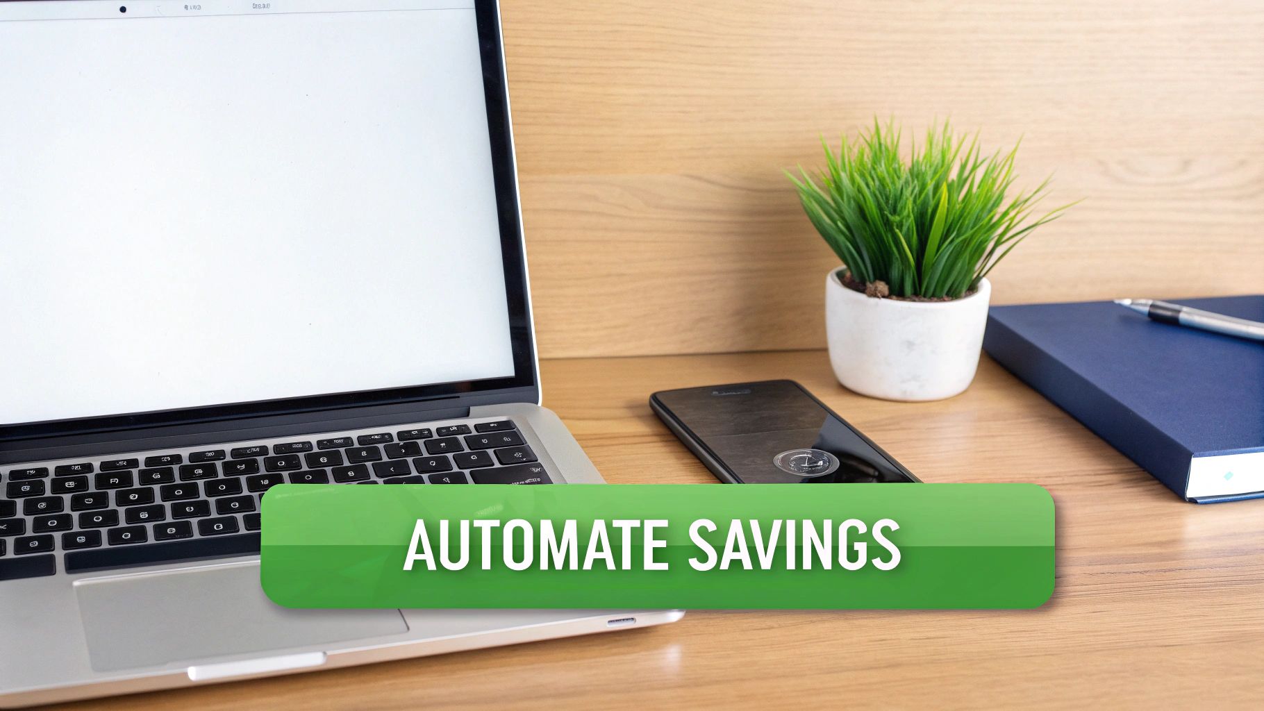 A desk setup with a laptop, smartphone, plant, and notebook, featuring a banner that says 'AUTOMATE SAVINGS'.