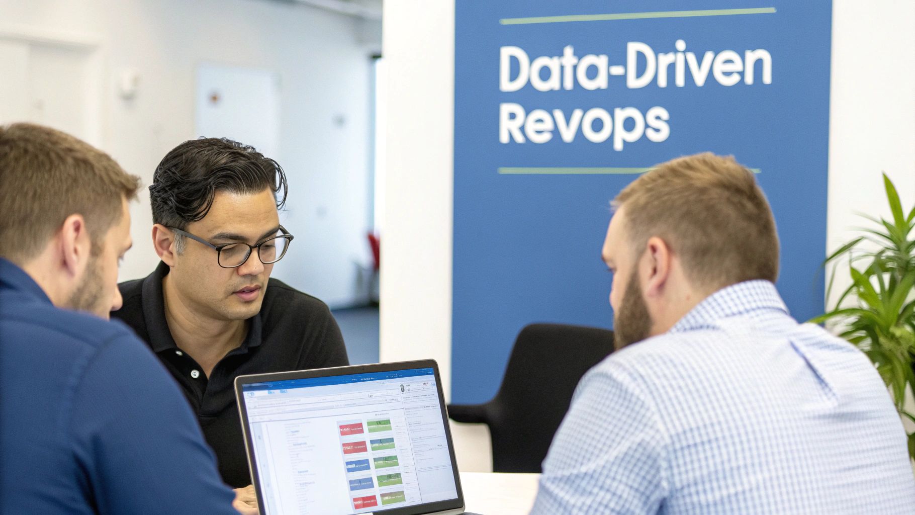 Three men collaborating on a laptop in an office, with a 'Data-Driven Revops' banner.