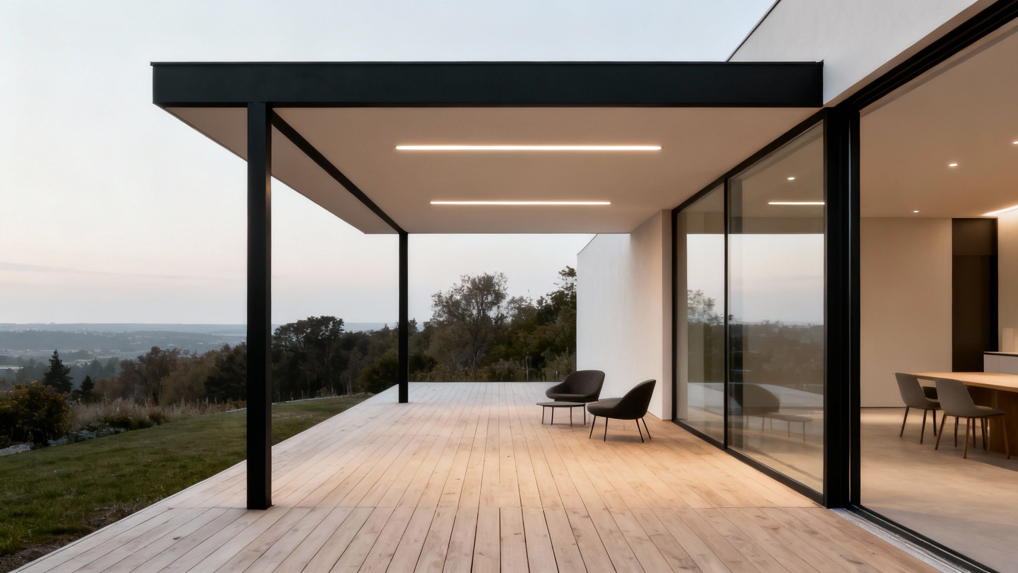 Moderne hus med stor overdækket træterrasse, stilfulde møbler og udsigt over et naturskønt landskab ved skumring.