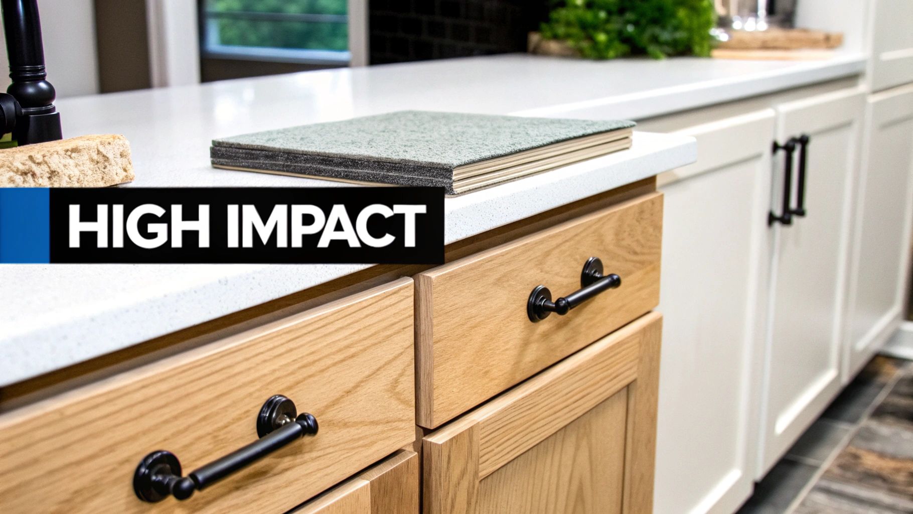 Modern kitchen counter with wood and white cabinets, black handles, and material samples for renovation.