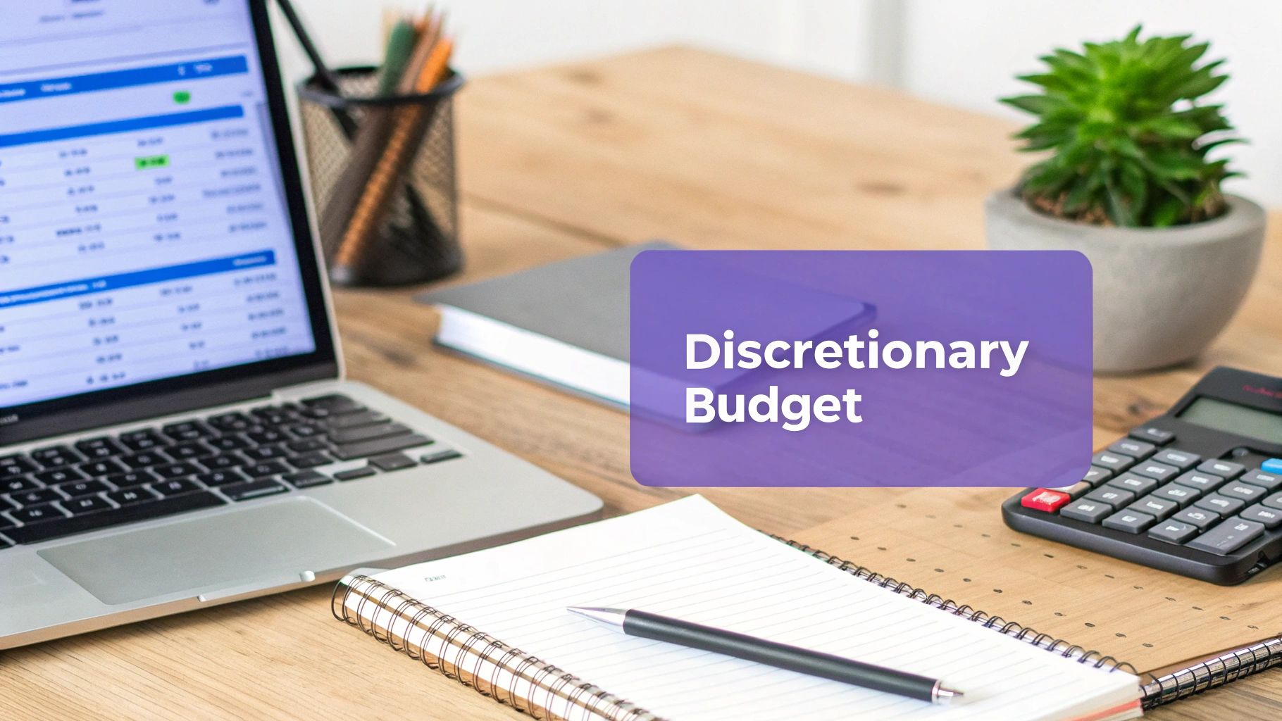 A desk with a laptop, calculator, notebook, and a text box displaying "Discretionary Budget".