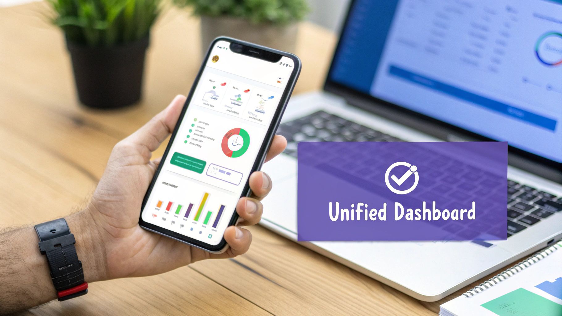 A hand holding a smartphone displaying a unified financial dashboard with charts and data.