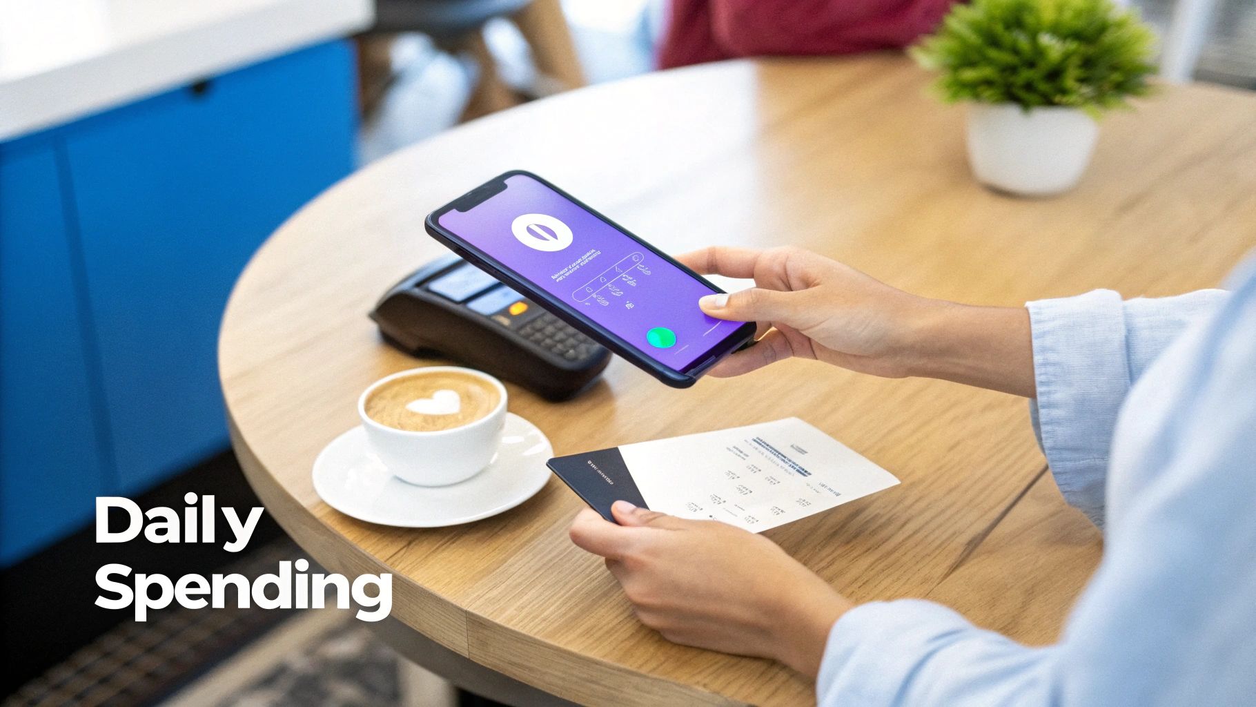 A person uses a smartphone to scan a receipt with a payment card on a wooden table.