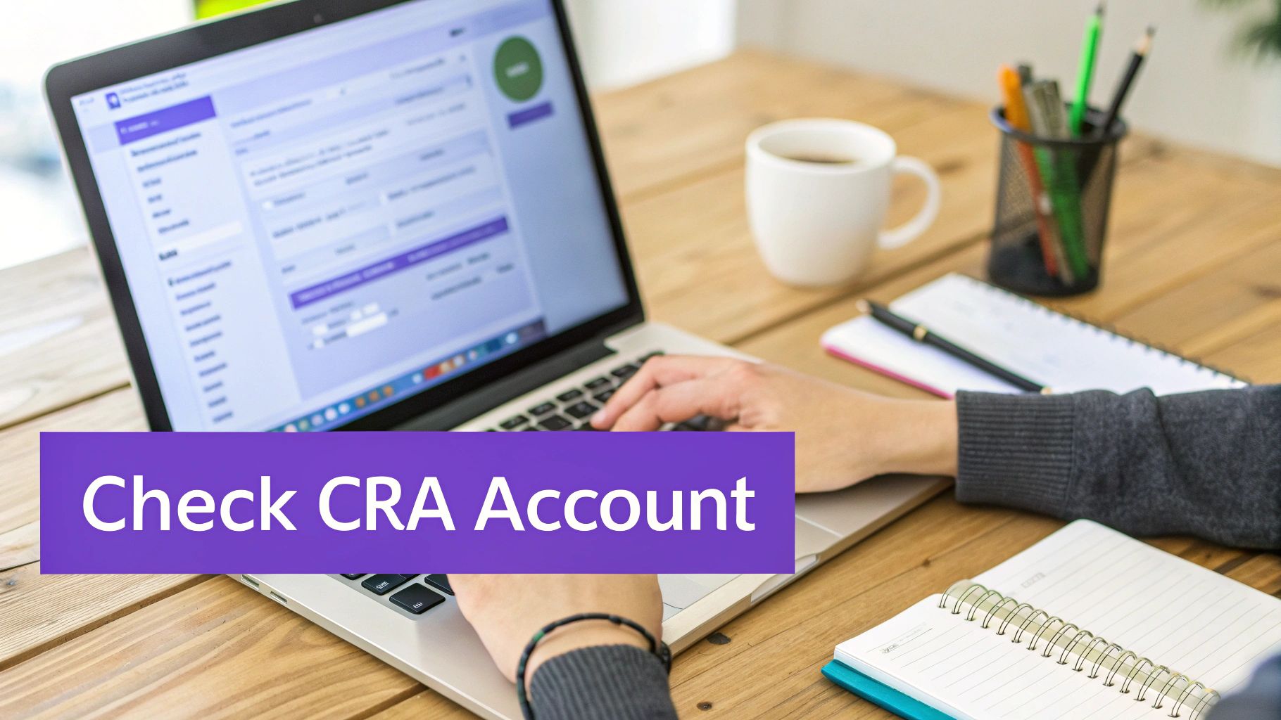 A person types on a laptop on a wooden desk with a coffee mug and notebooks, displaying 'Check CRA Account'.